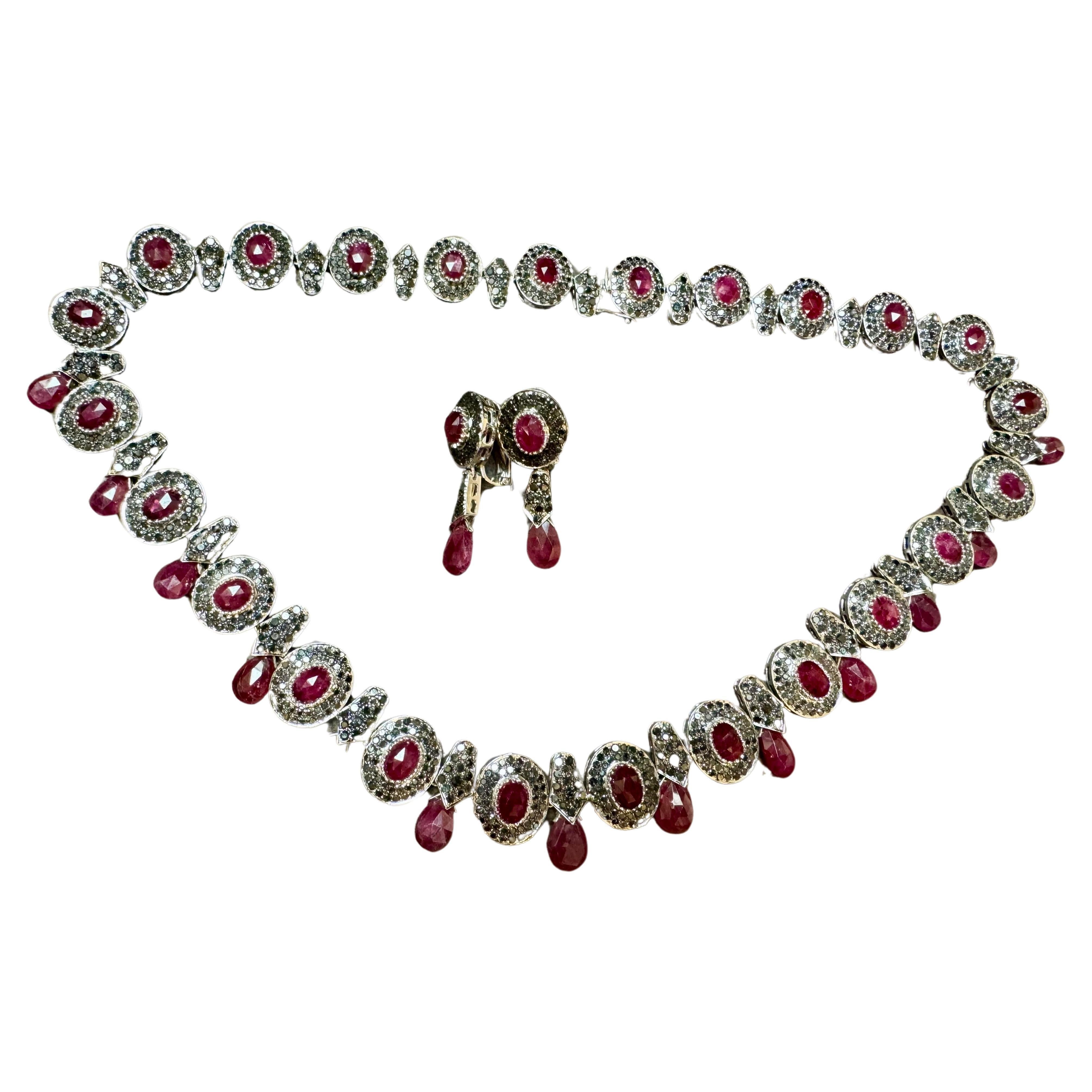  Necklace & Earring Suite 35 Ct Natural Ruby No Heat & Black & White Diamond 18KWG
This Large eye catching Collar Necklace with matching earrings are  crafted from 18 Karat gold and features Oval-shaped  natural Rubies, and ruby drops, totaling