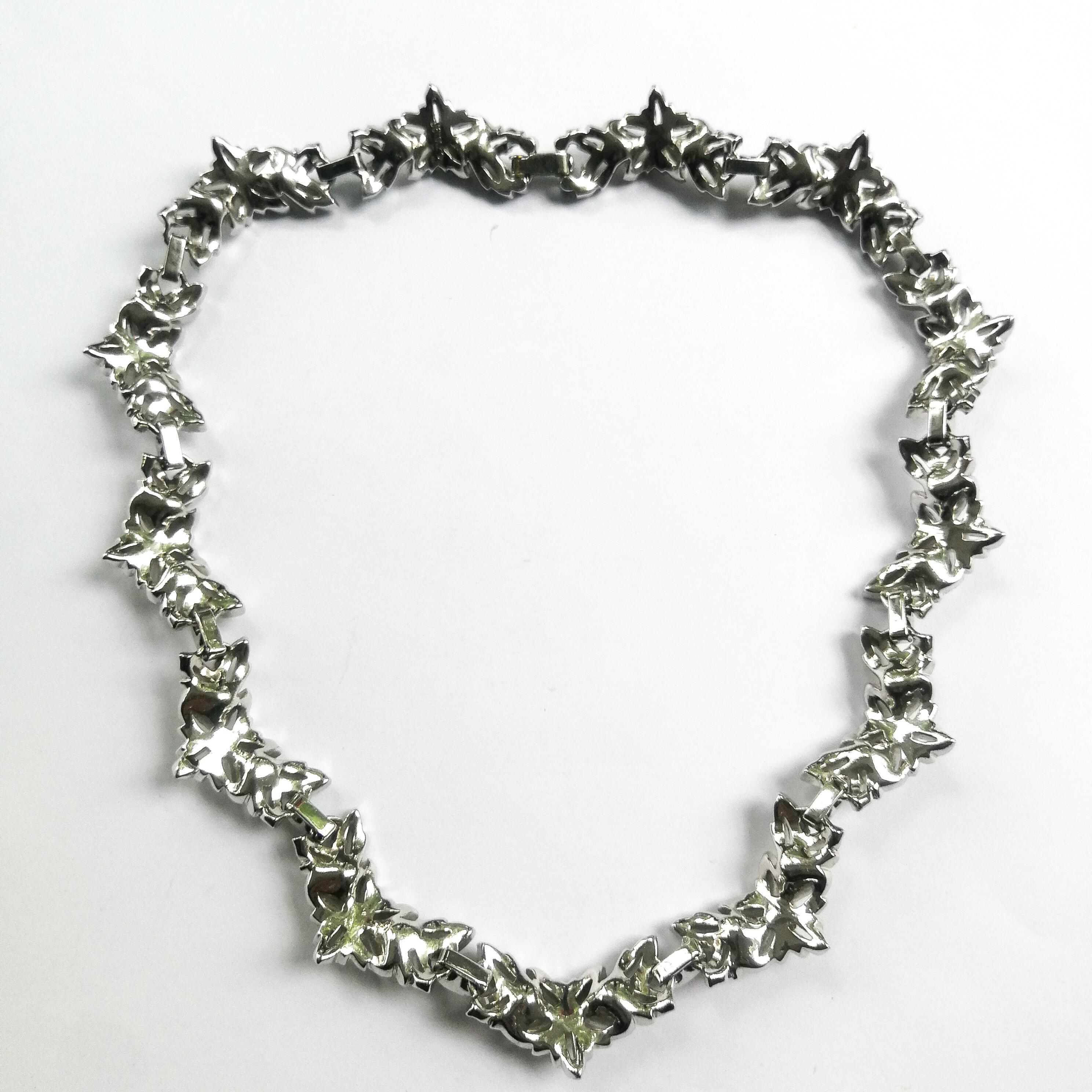 A very tailored and smart four piece parure, consisting of a choker necklace, earrings, bracelet and brooch, by the famous manufacturer Jomaz (Joseph Mazer), from the 1950s. Each piece set in rhodium plated metal, set with clear paste and paste