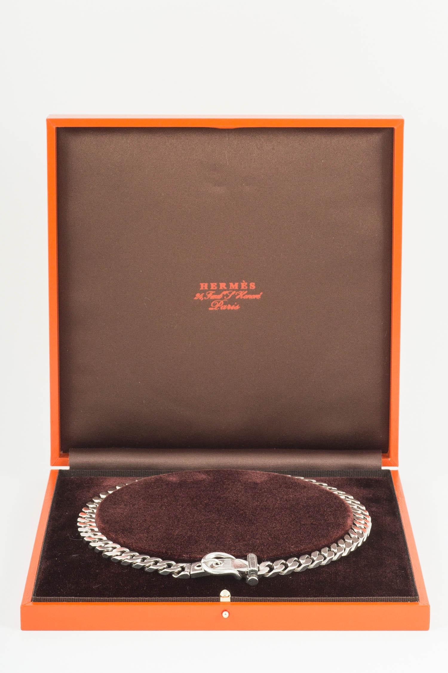 A heavy quality flat curb link chain necklace,with an opening buckle clasp at the front,signed Hermes Paris underneath the buckle,in fitted Hermes case.weight 85 grams,length 430mm,width 9mm.circa 1960