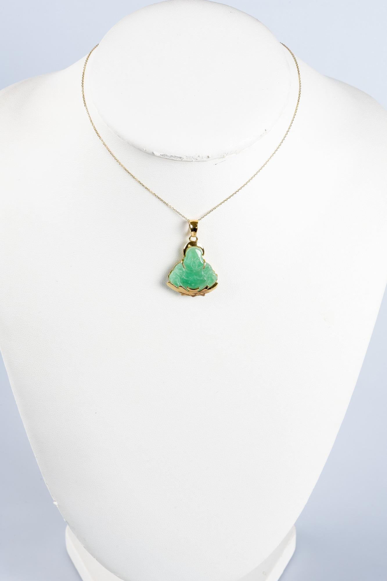 Necklace in 14 carats yellow gold composed of a chain in mesh and a pendant in the shape of Buddha decorated with a jade. The pendant represents the shape of a statue of Buddha, emblematic symbol of Buddhist spirituality and wisdom. It is made of