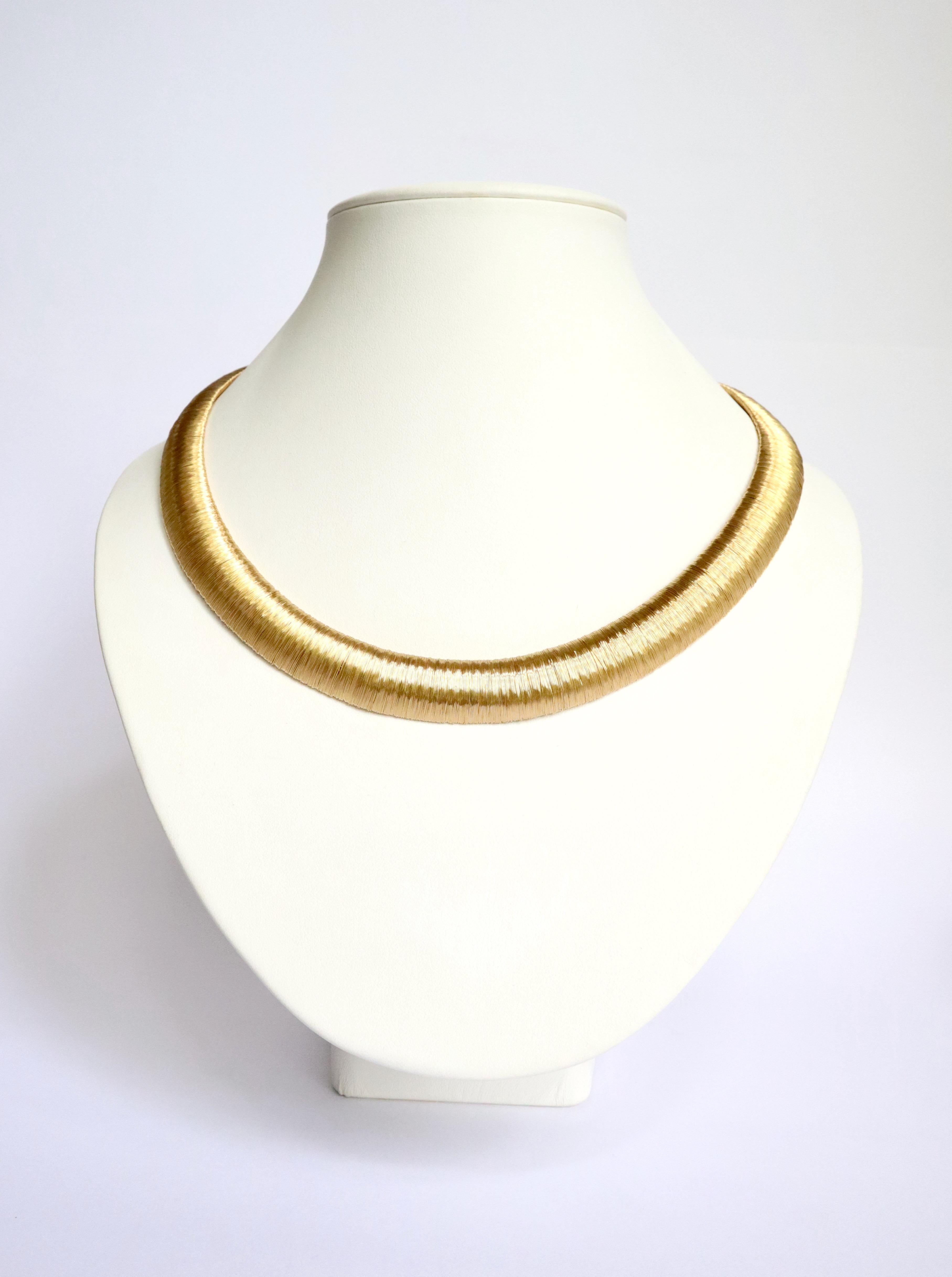 Halskette aus 18 Karat Gelbgold, bestehend aus einem Golddraht, der auf einen flexiblen Rahmen aus 18 Karat Gelbgold gewickelt ist. Dornschließe mit Sicherheits-Acht. 
Gewicht: 95,5 g. Länge: 50 cm
Adlerkopfpunze für 18 Karat Gelbgold