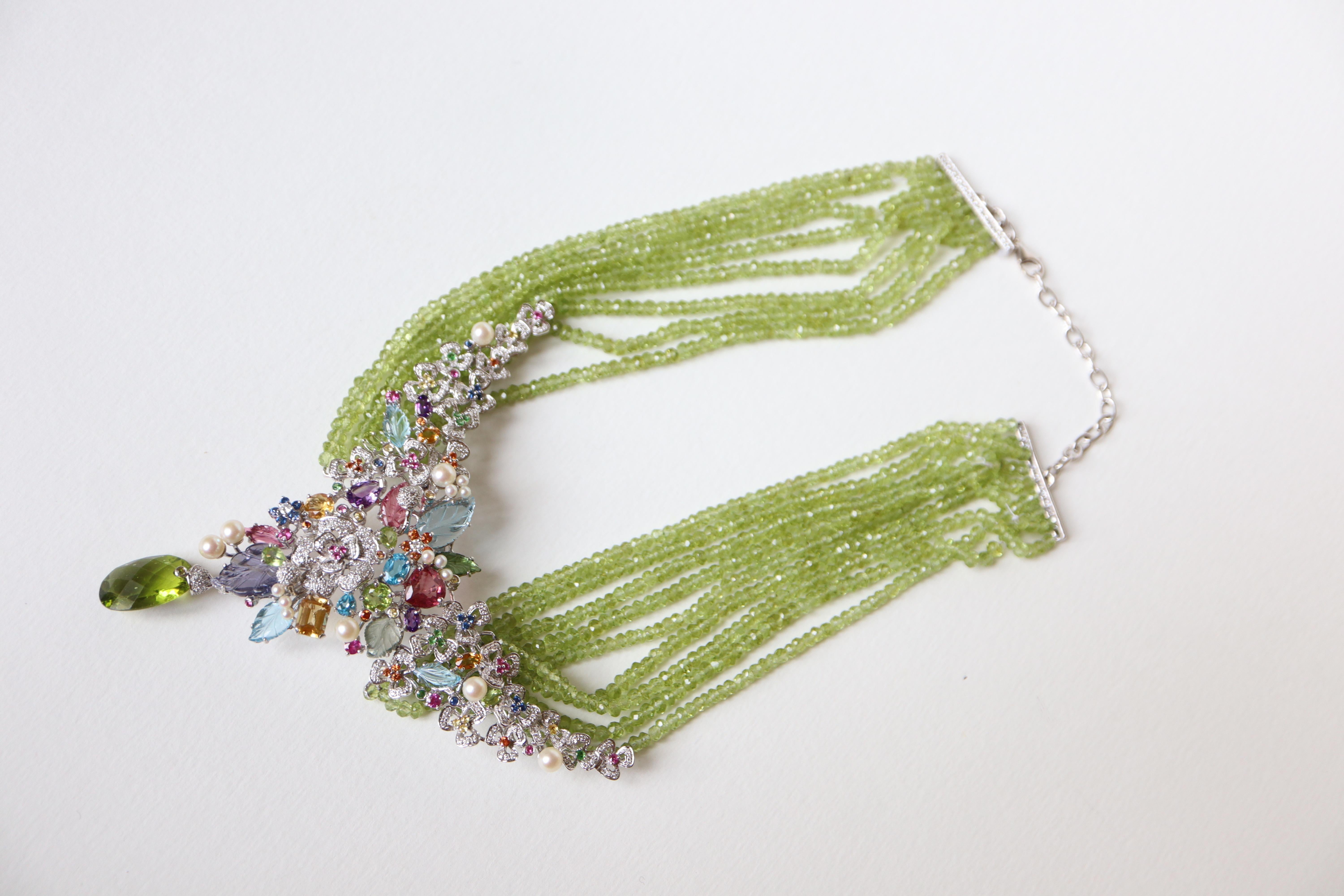 Tutti Frutti necklace in 18 kt white gold, diamonds, fine stones and quartz pearls.
Central Tutti Frutti motif retained by 8 rows of faceted green quartz beads attached to two white gold bars paved with diamonds. These bars held by two chains with