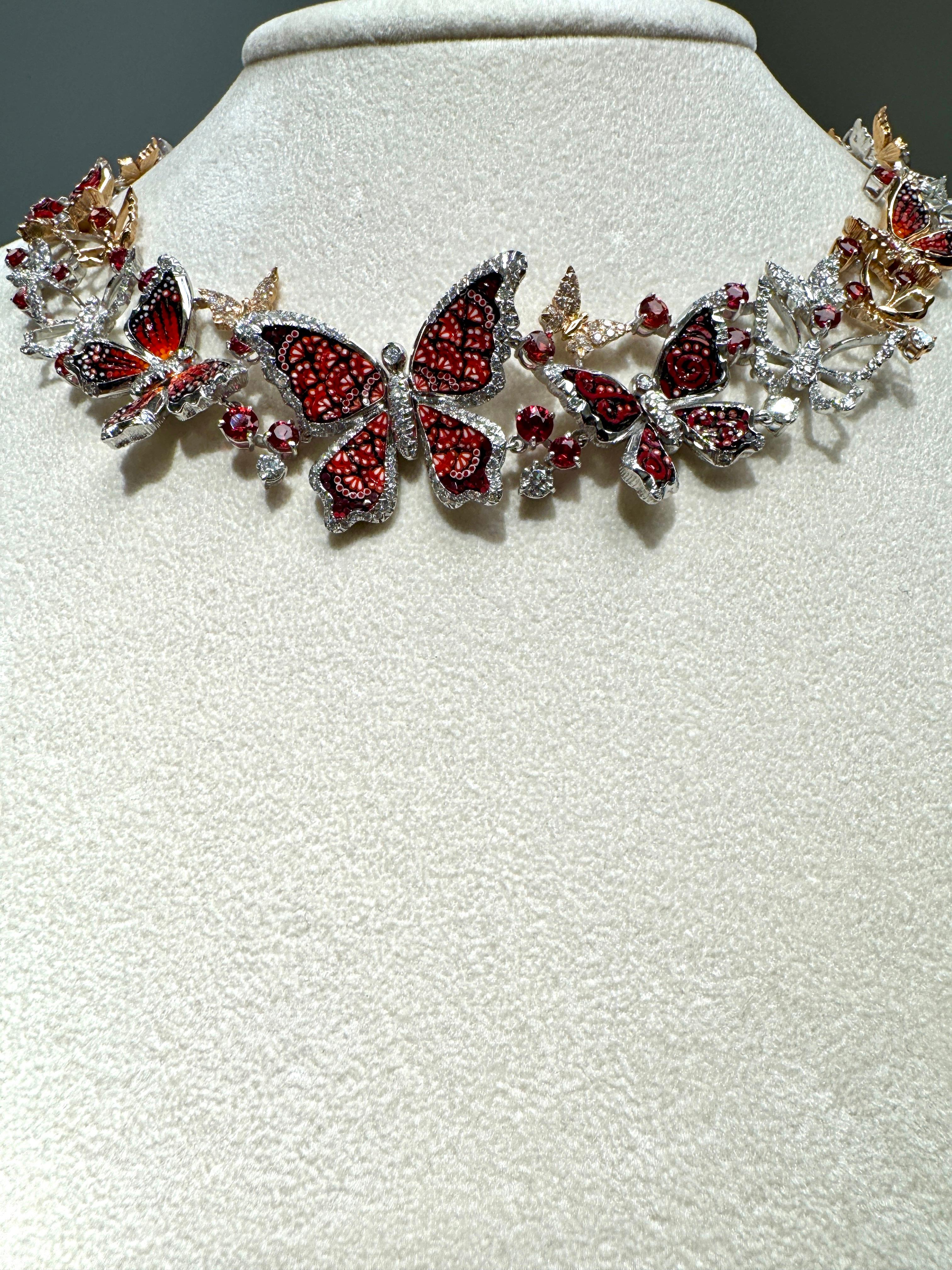 A delicate whirlwind of golden butterflies, decorated with red and black micromosaic tesserae in different shapes, along with orange sapphires and diamonds.

