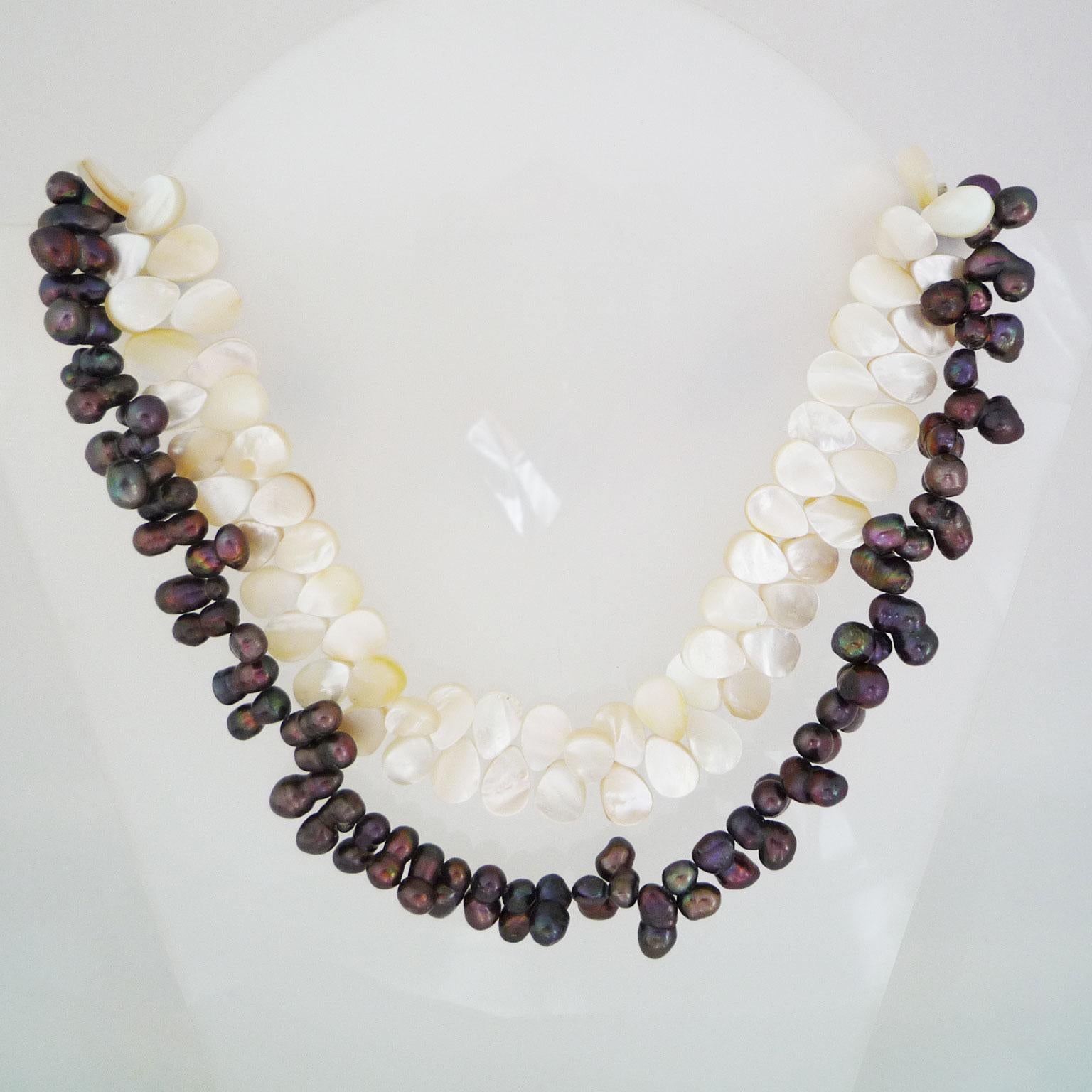 Necklace made of dark pearls and mother-of-pearl plates
double row necklace made of dark pearls and mother-of-pearl plates connected at the clasp with hearts made of agate
magnetic fastener

Hand-knotted.
Modern design object.
Chain length 53