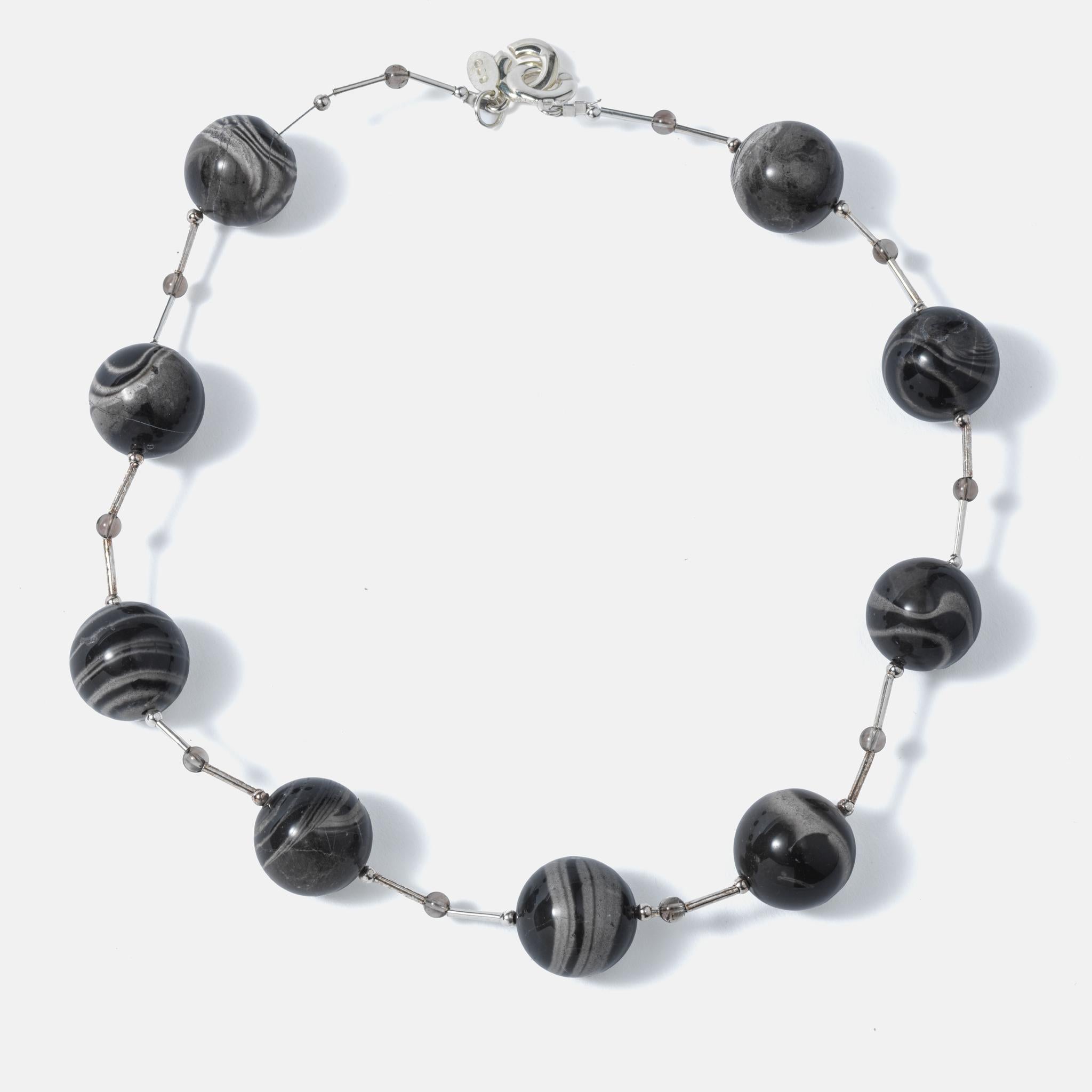 A modern and playful necklace made of silver pools with large balls of zebra jasper. Made by Ragnar Levi (1961-) who is a Swedish artist that have been working in many fields to create his works. 
This is a great example of his works.
