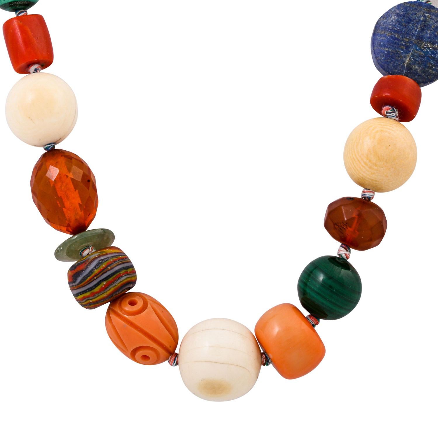 (Coral treated, amber, artificial glass, malachite, lapis lazuli, mother-of-pearl and bone), L: 54cm. (18)

 Necklace with various gemstones (coral, amber, artificial glass, malachite, lapis lazuli, mother-of-pearl and bone), L: 54cm.