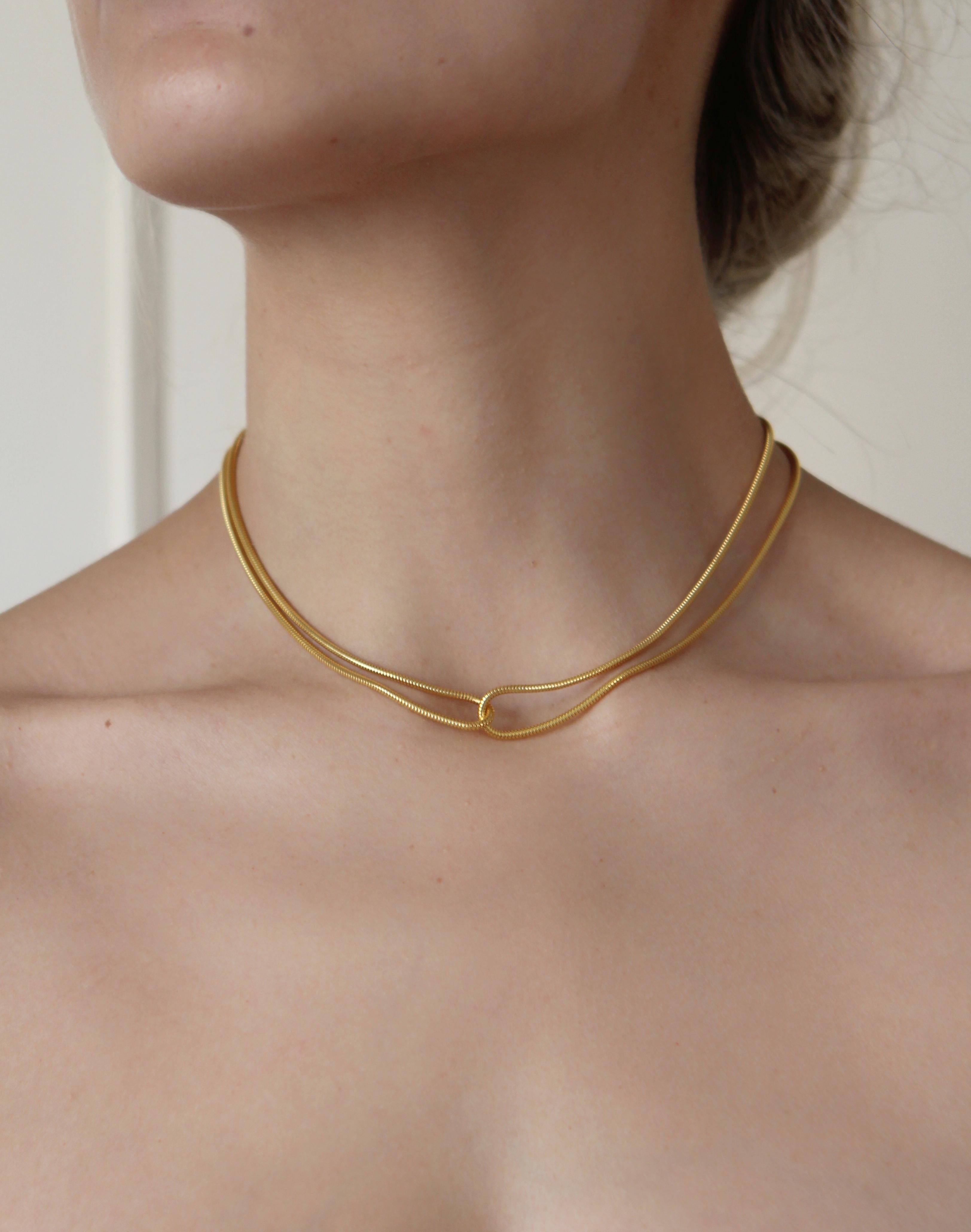  
This necklace  consists of two yellow gold chains looped through each other. This is a very graceful piece inspired by nature's delicate shapes and movement, bringing elegance to any outfit.

Hand-crafted by local skilled Greek craftsmen.

This