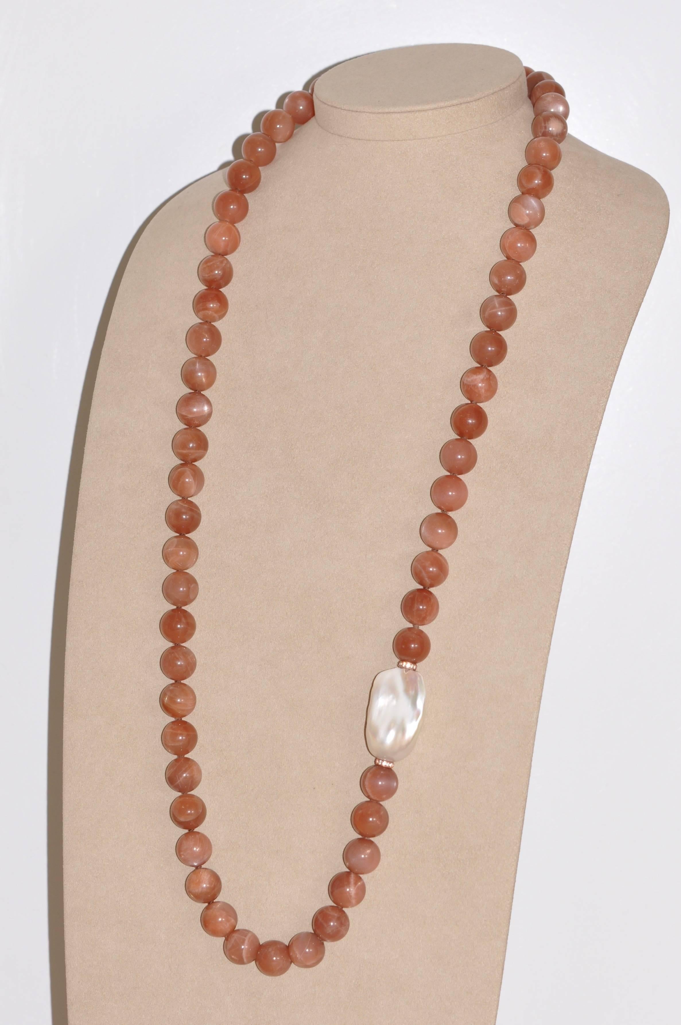 A sumptuous moon pearl necklace, a piece of jewelry that dazzles with its celestial beauty. Combining the softness of baroque freshwater pearls, the subtlety of peach moonstone and the bewitching brilliance of topaz, this jewel is a true treasure to