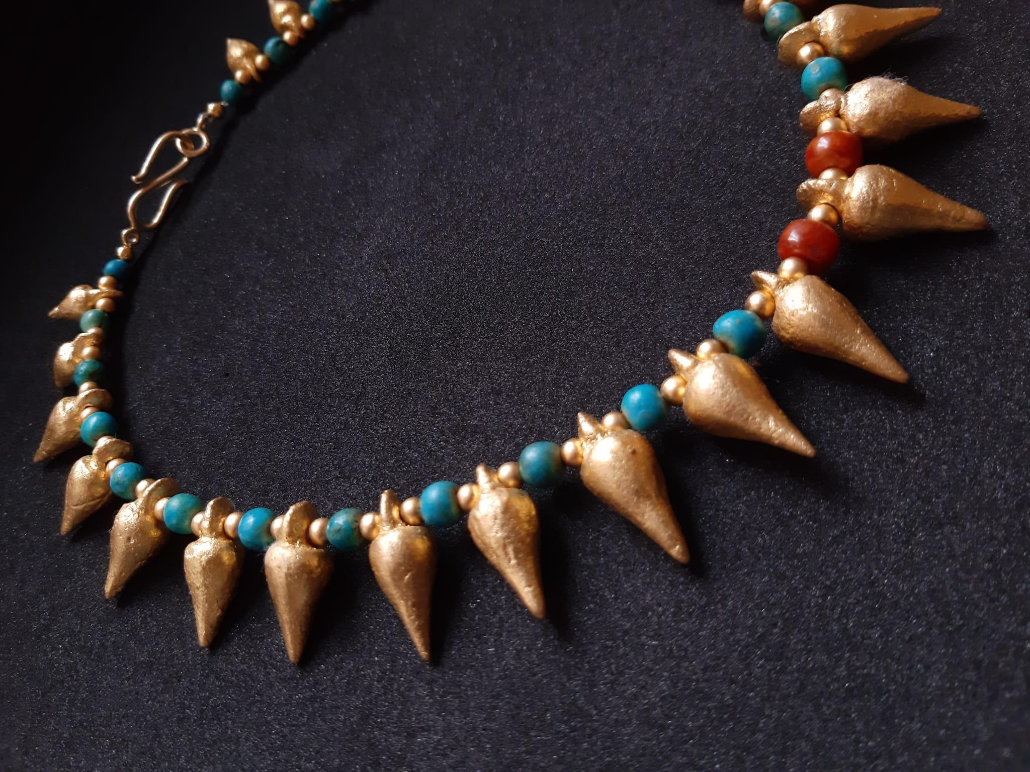 Stunning restrained necklace consisting of 25 Greek early Hellenistic gilt terracotta Amphora shaped pendants and 26 ancient Egyptian stone beads in between (24 turquoise and 2 carnelian), complemented by tiny gilt metallic beadlets. Golden S-form