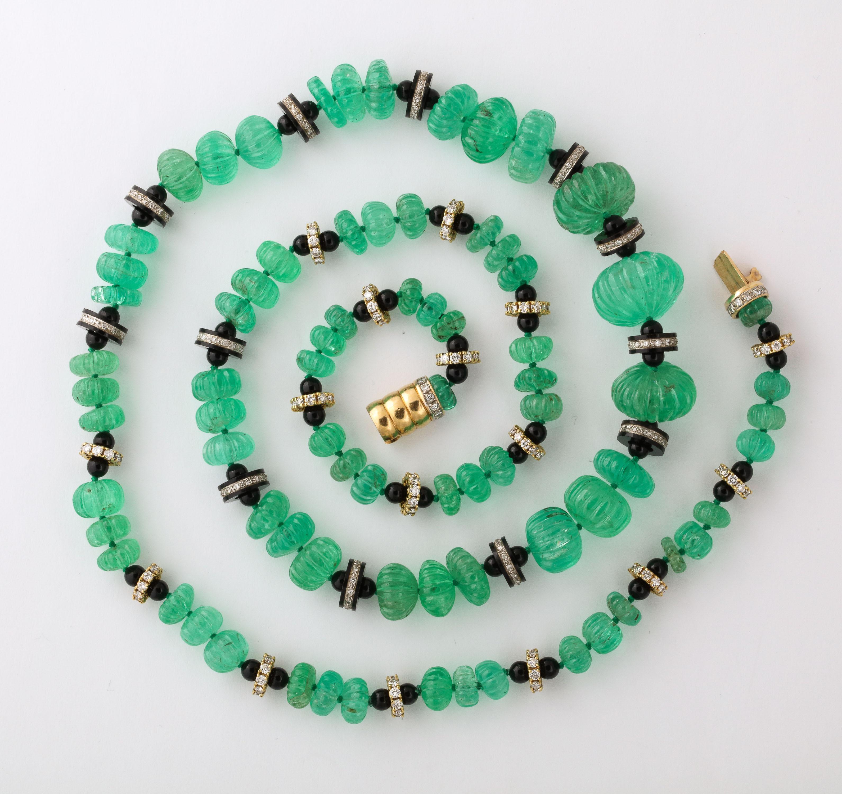 Sumptuous Long necklace of Carved graduated Emerald Beads with Black Onyx & Diamond spacers terminating with a Yellow Gold & Diamond Clasp.  Wow - what a look.  Over 300 carats of Emeralds & 3  carats of Diamonds.  
