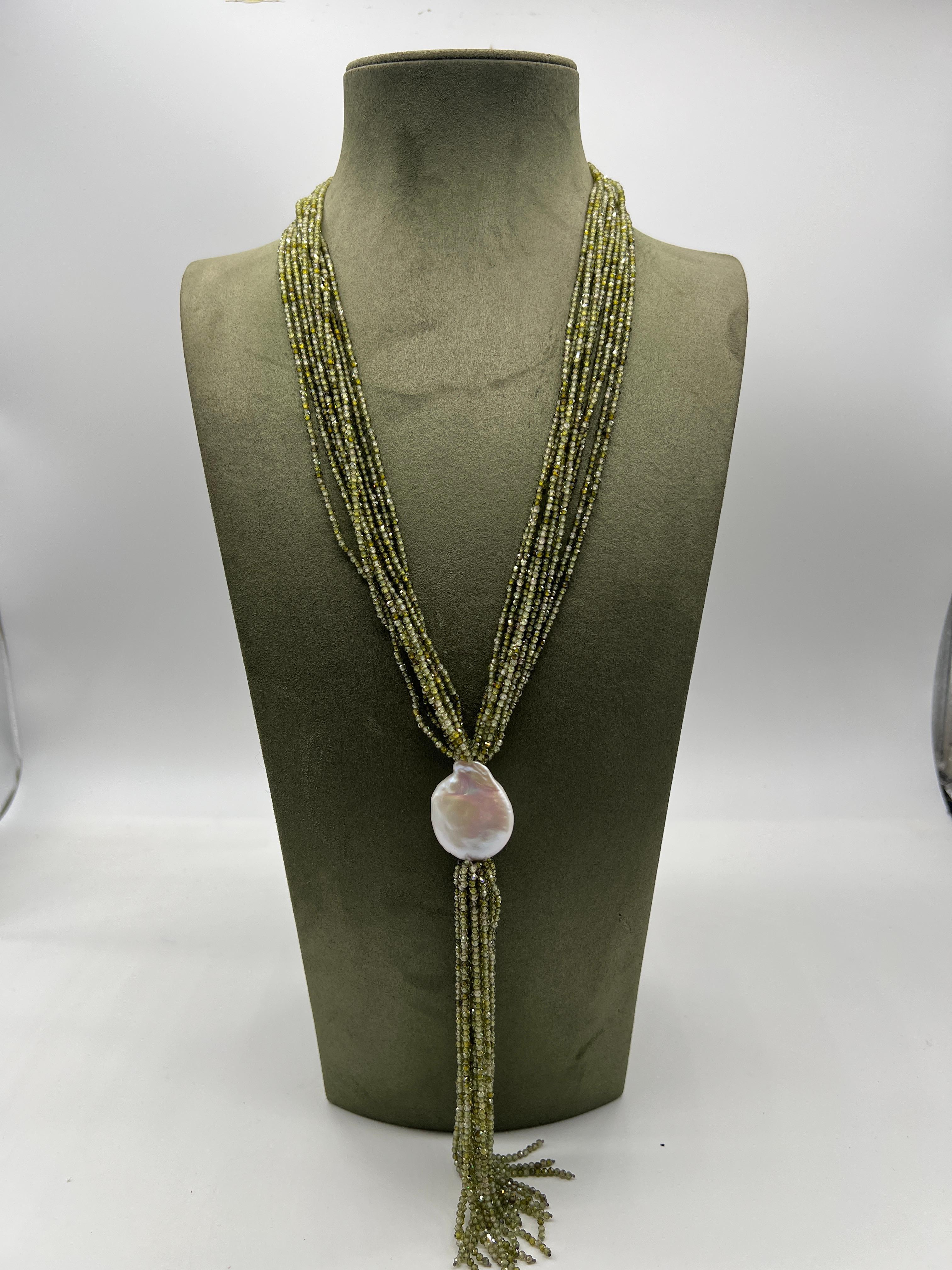 Collier Sautoir Zirconia Vert Perle Baroque Bakelite 

Cet élégant sautoir est composé de perles de zirconium vertes.
 Il présente une multitude de franges de perles qui se rejoignent sur une seule perle baroque blanche. 
La frange tombante ajoute