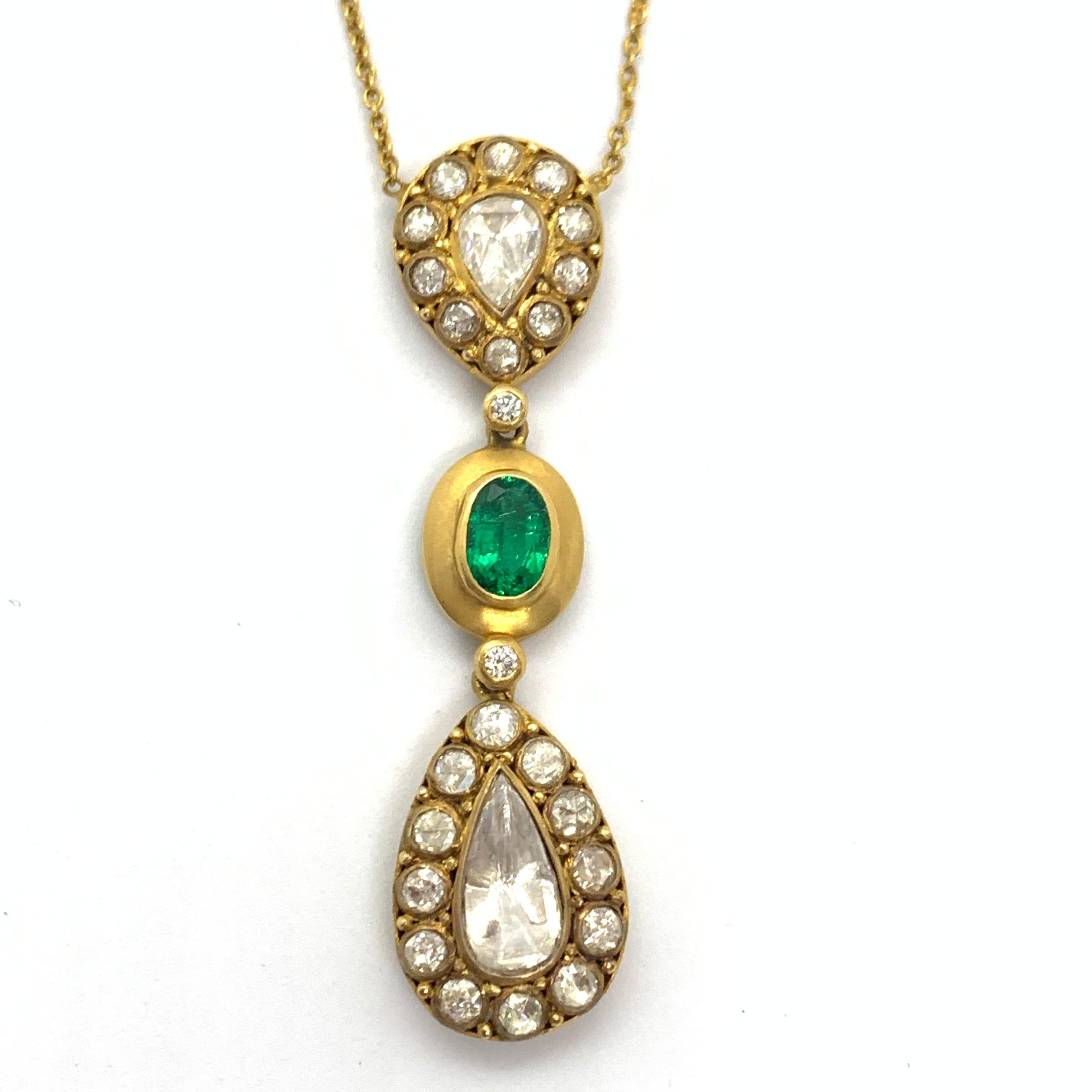 An exquisite necklace with a combination of Diamond Rose Cuts and a beautiful Emerald Oval in the center. The emerald is from the Zambian Mines and is a very nice vibrant Green Colour. The pendant is hung in a 18K Gold chain with round diamond rose