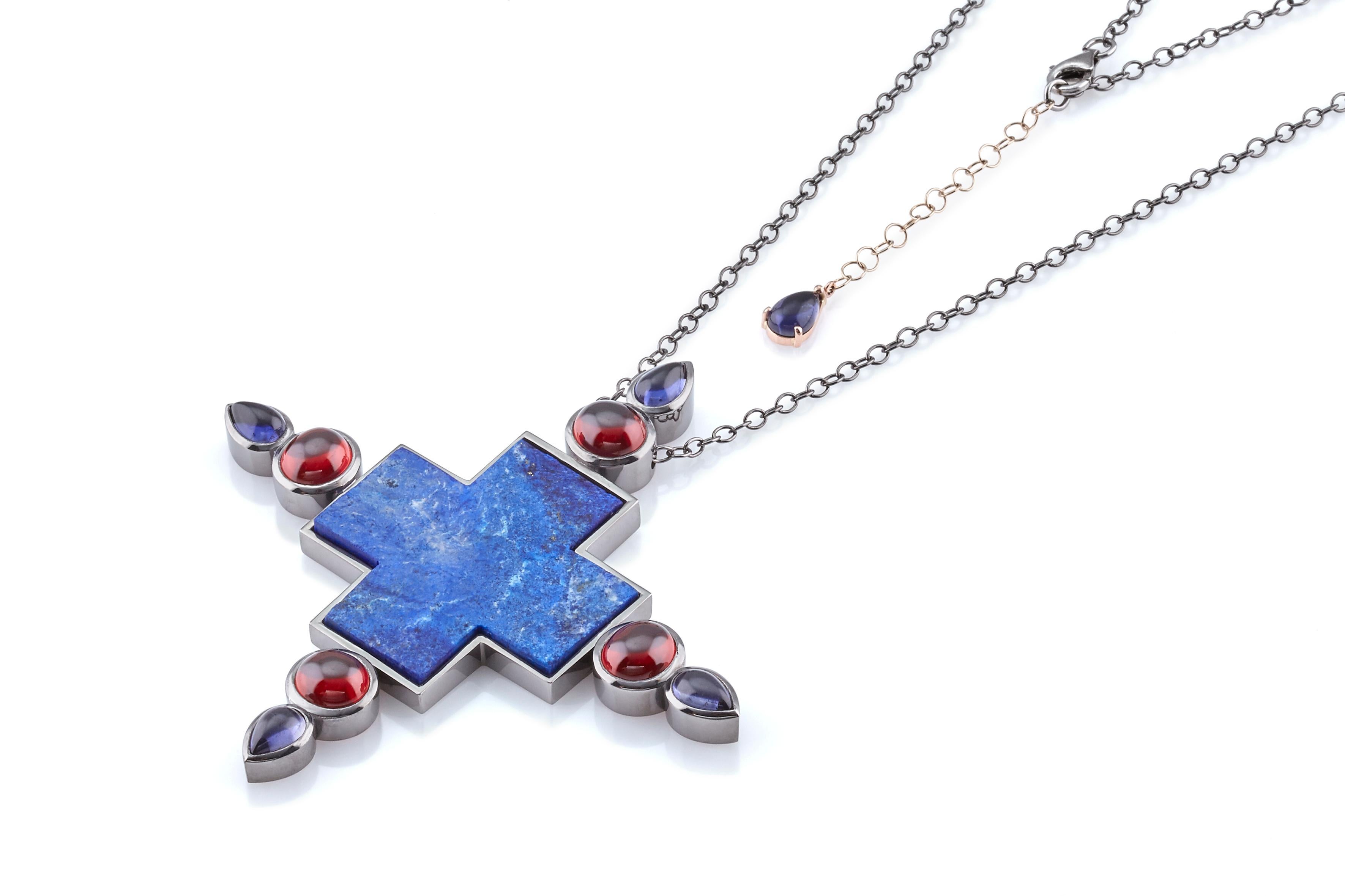 One Of A Kind Cross Necklace, in oxidised Sterling Silver and 18 kt Gold decorative with a rare Lapis Lazuli rough blue cross, Iolite and Garnet cabochon.
This big Handcrafted, dramatic, avant-garde and original cross with a distinct Eastern twist,