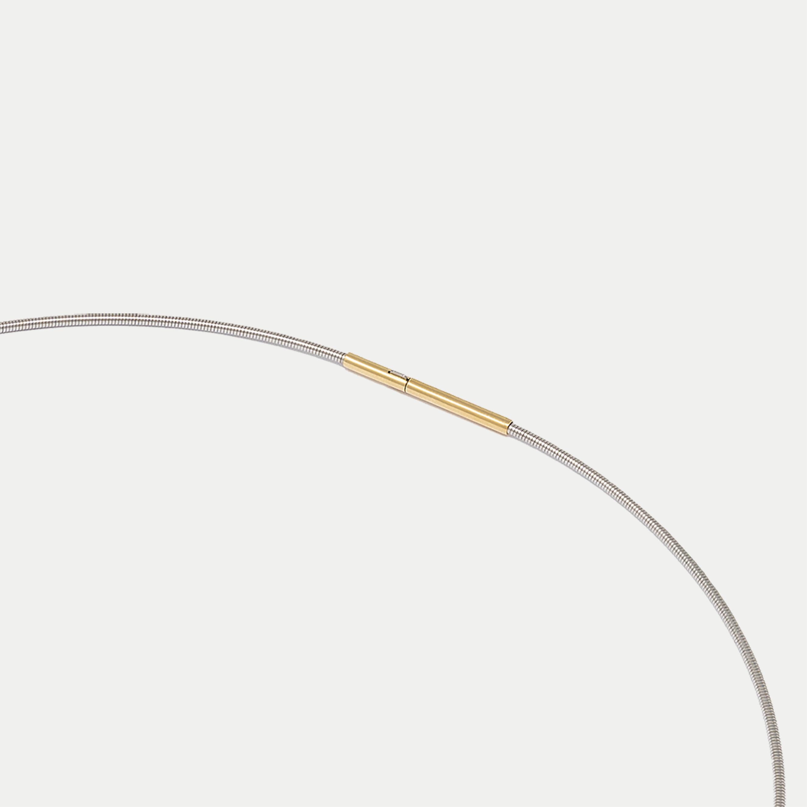 Flexible steel necklace with 18 carat yellow gold clasp (42 cm length)
Mosca pendant in 18 carat white gold

The owner decides how to wear this necklace: keep it simple and minimalist, wearing only the necklace or transform it into a more complex
