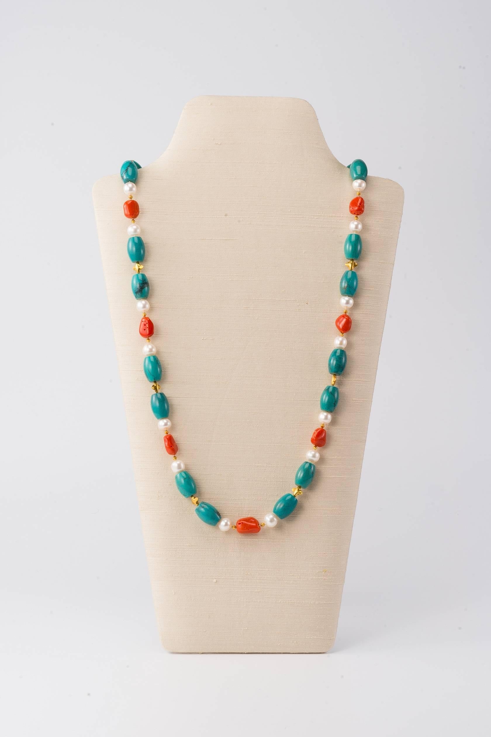 34 in (86.5cm) long necklace with Tibetan turquoise, Sardinian coral pebbles, freshwater pearls and 18K gold beads & clasp

This classic mix of turquoise, coral & pearls with gold bead accents can be worn long or twisted double around the neck. 