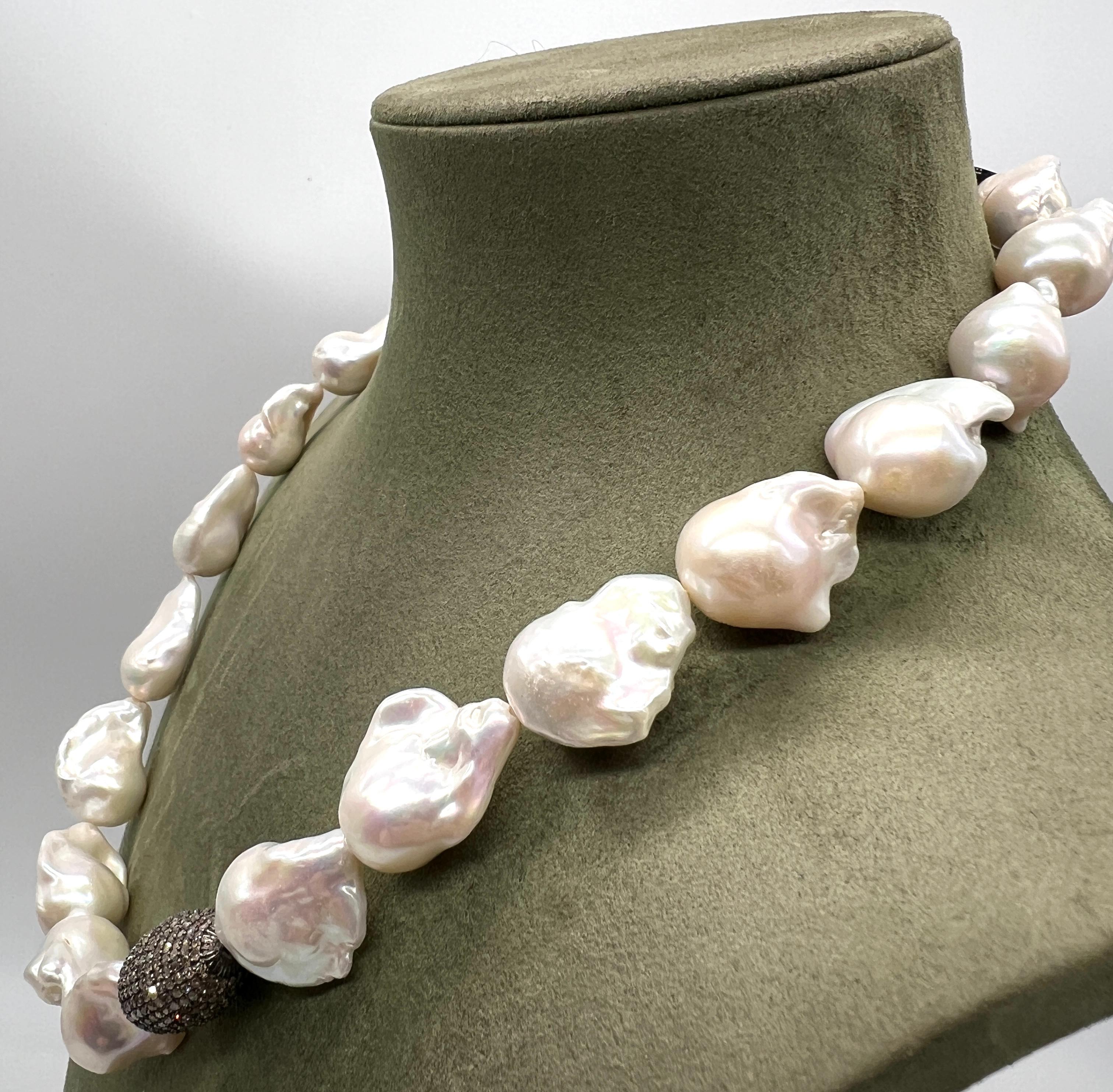 Collane Collane barocche Perle, bachelite

Questa collana è composta da 21 perle, una delle quali è incastonata con piccoli diamanti a taglio brillante. Le altre perle, di stile barocco, sono bianche e aggiungono un tocco unico all'insieme. La