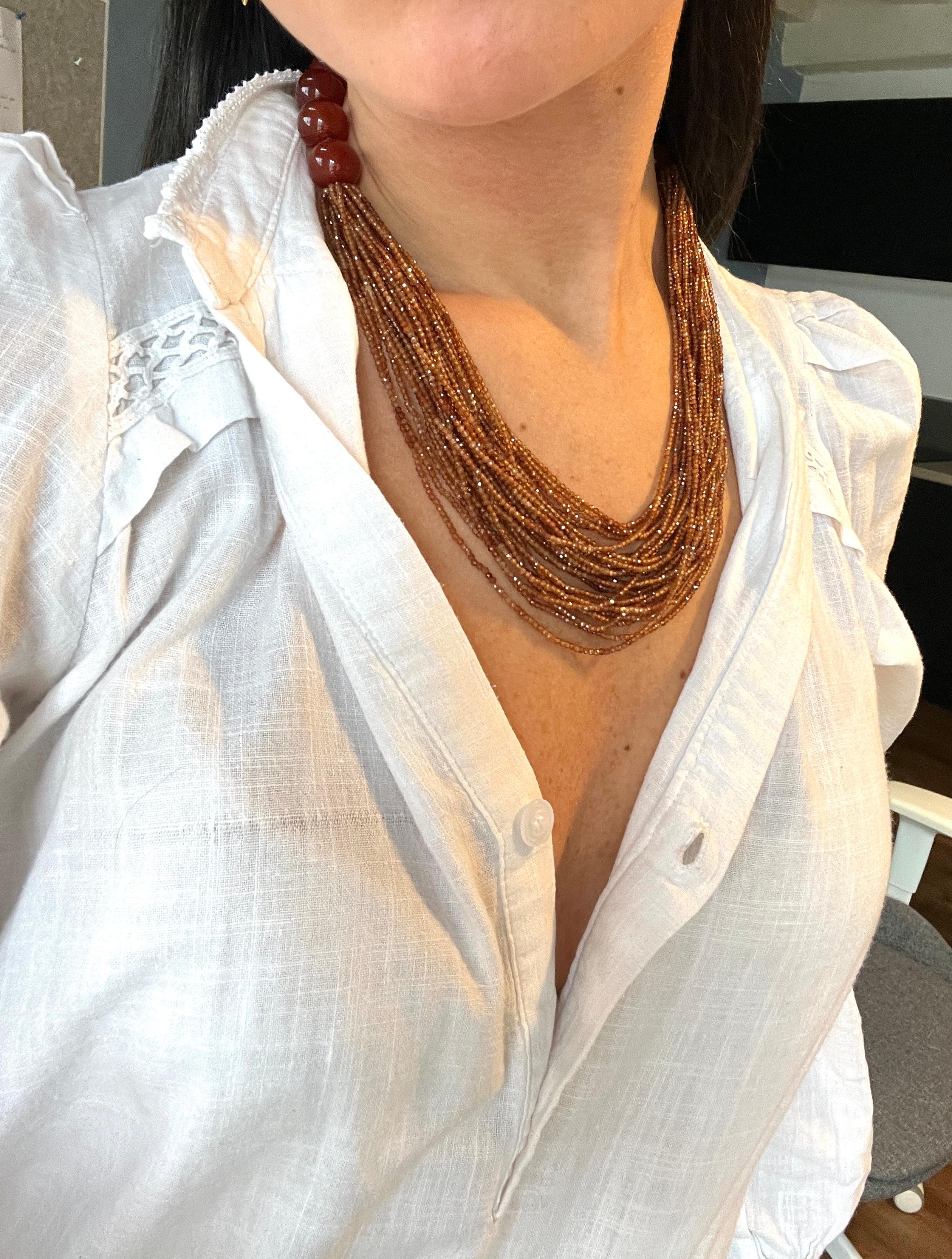 Scollatura in hessonite rossa e bachelite. 

Questa collana raffinata e moderna presenta 11 perline di agata rossa, una pietra apprezzata per le sue tonalità profonde e la sua energia rilassante, mentre il resto del Jewell è ornato da 27 delicate