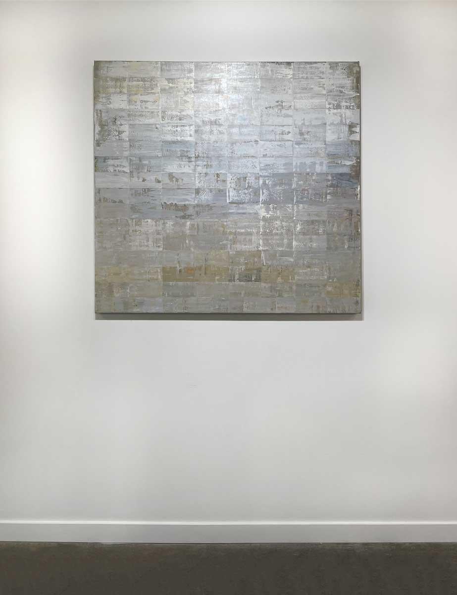 This abstract, contemporary painting by Ned Martin features a light, metallic, and neutral palette. A grid of textured rectangles are patterned together side by side, with varying layers of grey, gold, and white paint. It pairs beautifully with