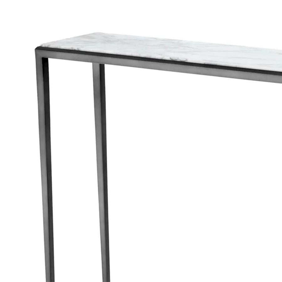 Console Table Bronze Needle with structure in
steel in bronze finish and with white marble top.
Marble's veins change depending on the block 
of marble from which the top is cut. Each top is 
a little different but the quality of the marble.
Also