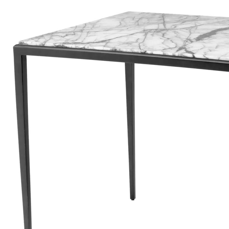 Table d'appoint Bronze Needle avec structure en
acier en finition bronze et avec un plateau en marbre blanc.
Les veines du marbre changent en fonction du bloc 
de marbre dans lequel est taillé le sommet. Chaque plateau est 
un peu différent mais la