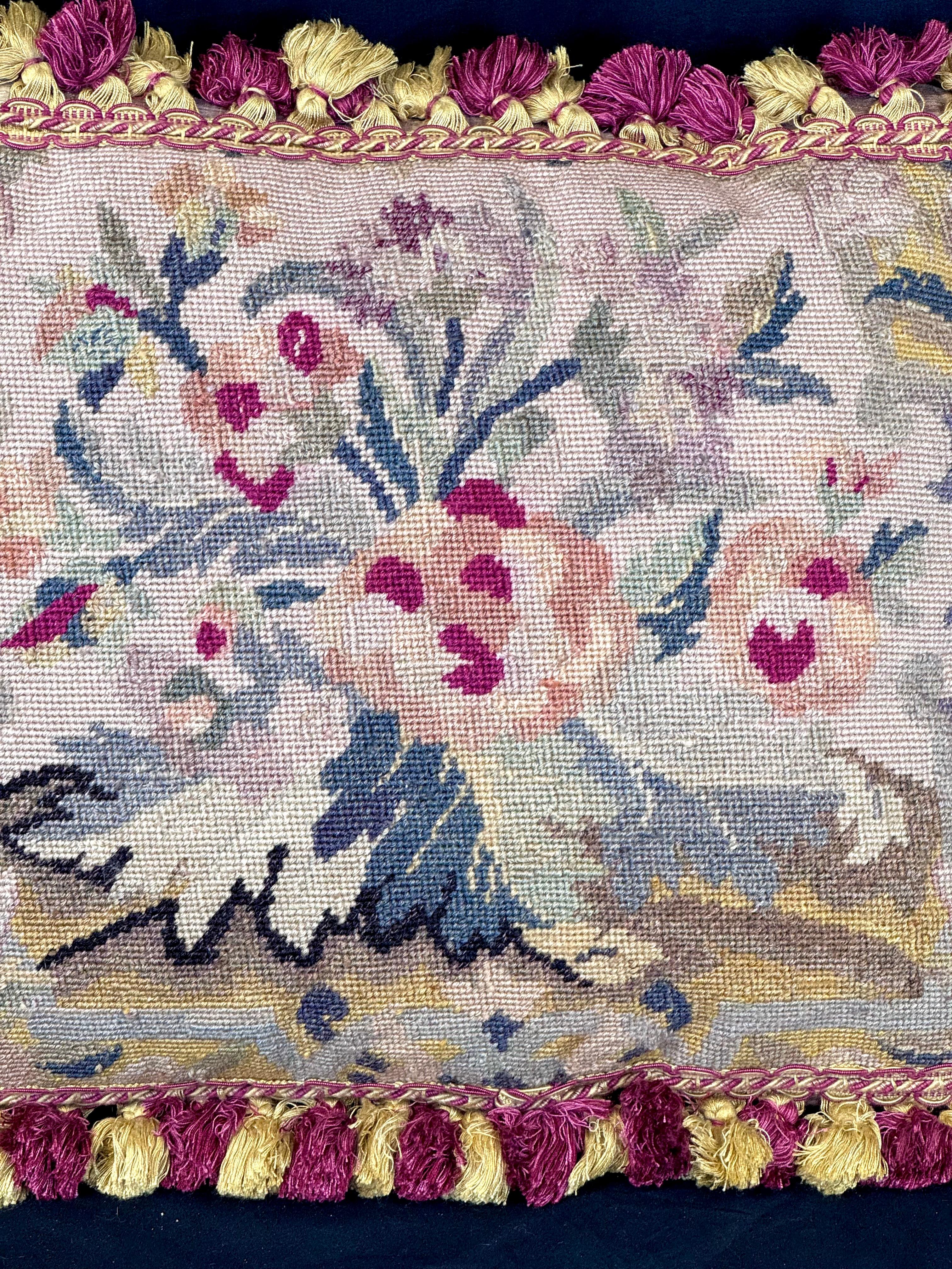 Oreillers en tapisserie florale à l'aiguille du 19e siècle, ensemble de deux. Chaque oreiller présente d'exquis motifs floraux cousus à la main dans des teintes chaudes et romantiques. Le motif central représente un bouquet de roses et de fleurs