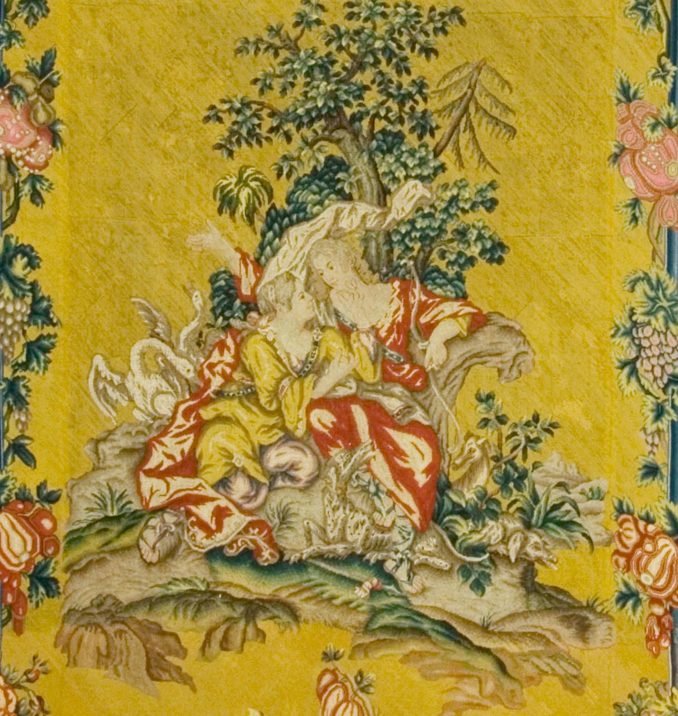 Needlepoint panel of a mythological scene in the manner of Boucher. One of a pair of arched panels possible Entre Fenetres, the orange yellow grounds display each an arch of fruits and flowers and a swag of similar character. There is a suspended