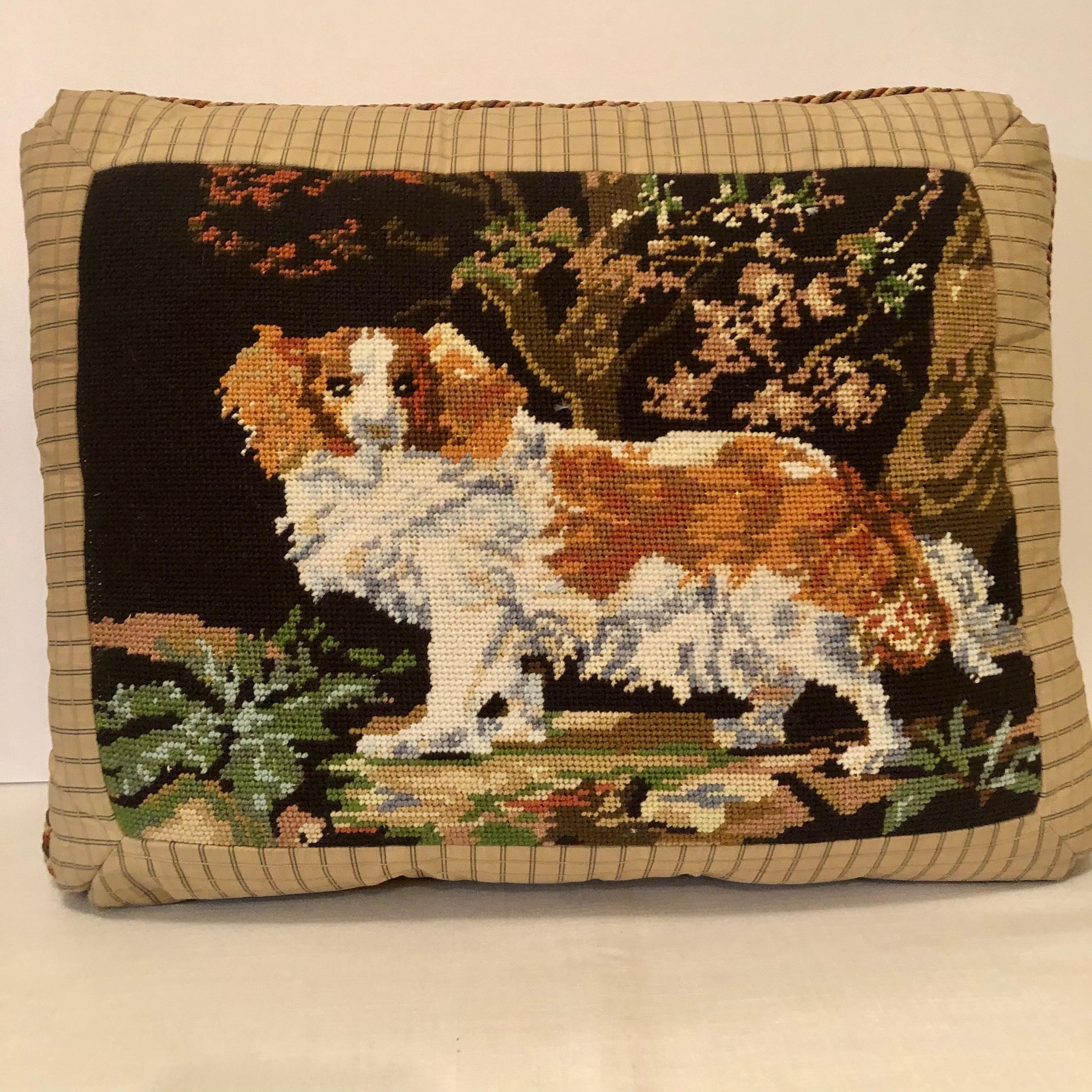 Beautiful and charming needlepoint pillow with a needlepoint picture of a King Charles spaniel playing in the woods. It has beige and brown cording around the pillow with a nice beige ground color fabric on the back. This pillow is in very good