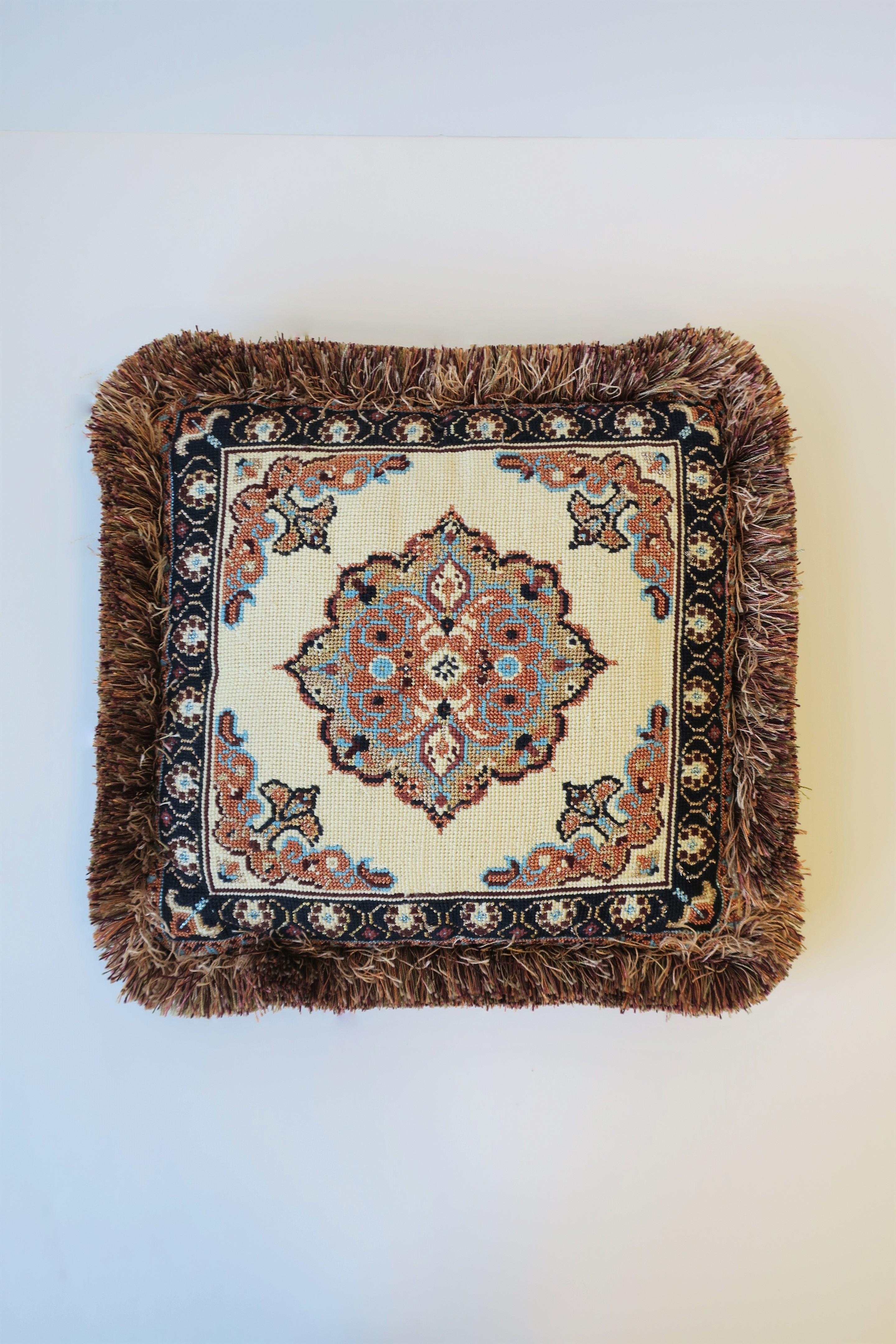 A beautiful handmade needlepoint pillow with a Moroccan/Moorish design style, circa 21st century. Pillow has a beautiful center medallion, detailed corners, fringe edge, and an orange silk back. Colors include turquoise blue, metallic sand/tan,