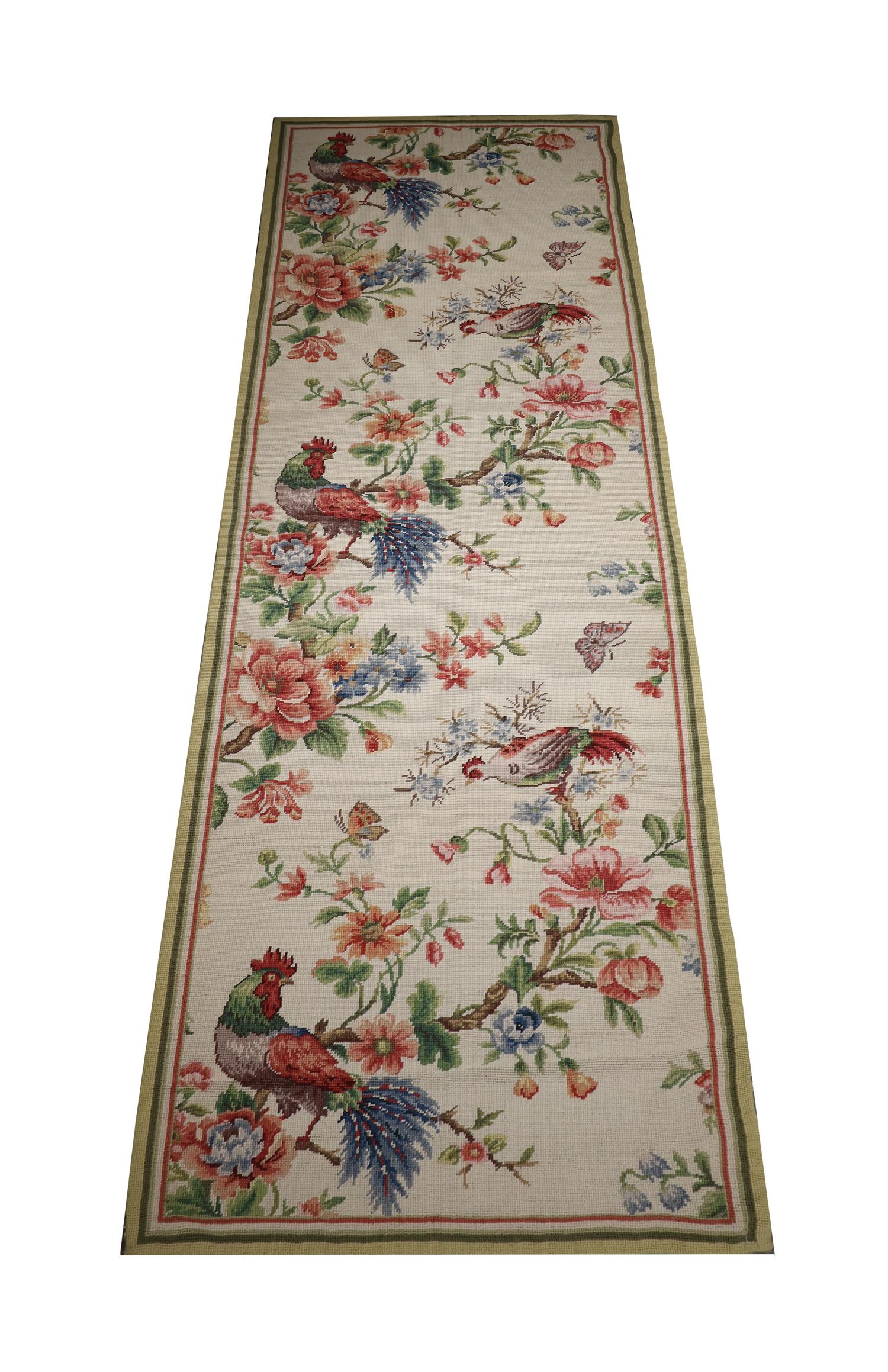 The design of this needlepoint rug features a simple cream background with accents of green, pink and blue that make up the flowers and animals. Beautifully woven with delicate details throughout, creating an elegant accent rug sure to uplift any