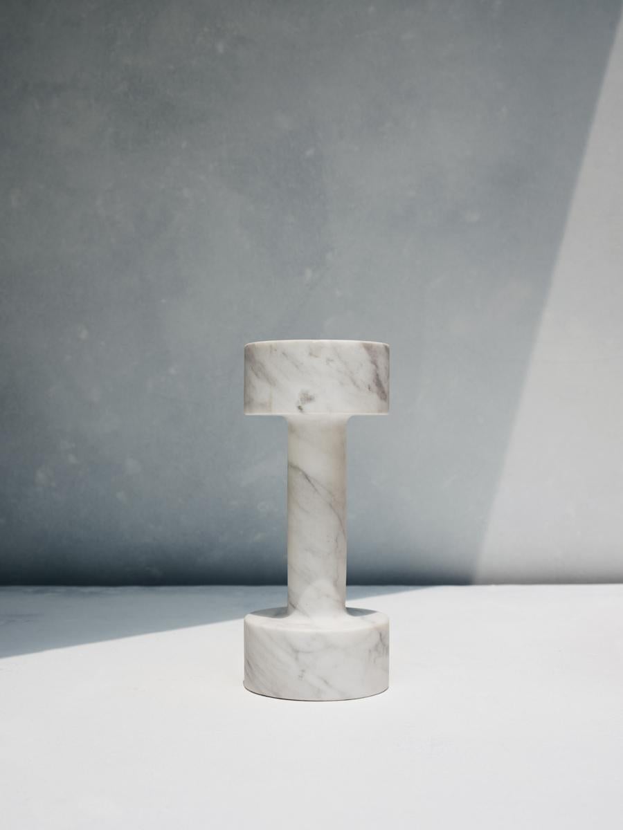 Nefeli dumbell by Faye Tsakalides. 
Dimensions: 17 W x 7 L x 7 H cm
Materials: White volakas marble. 
Technique: Crafted from a single piece of marble. Hand-crafted, Polished. Mat finished. 

Faye Tsakalides is a Greek architect and designer
