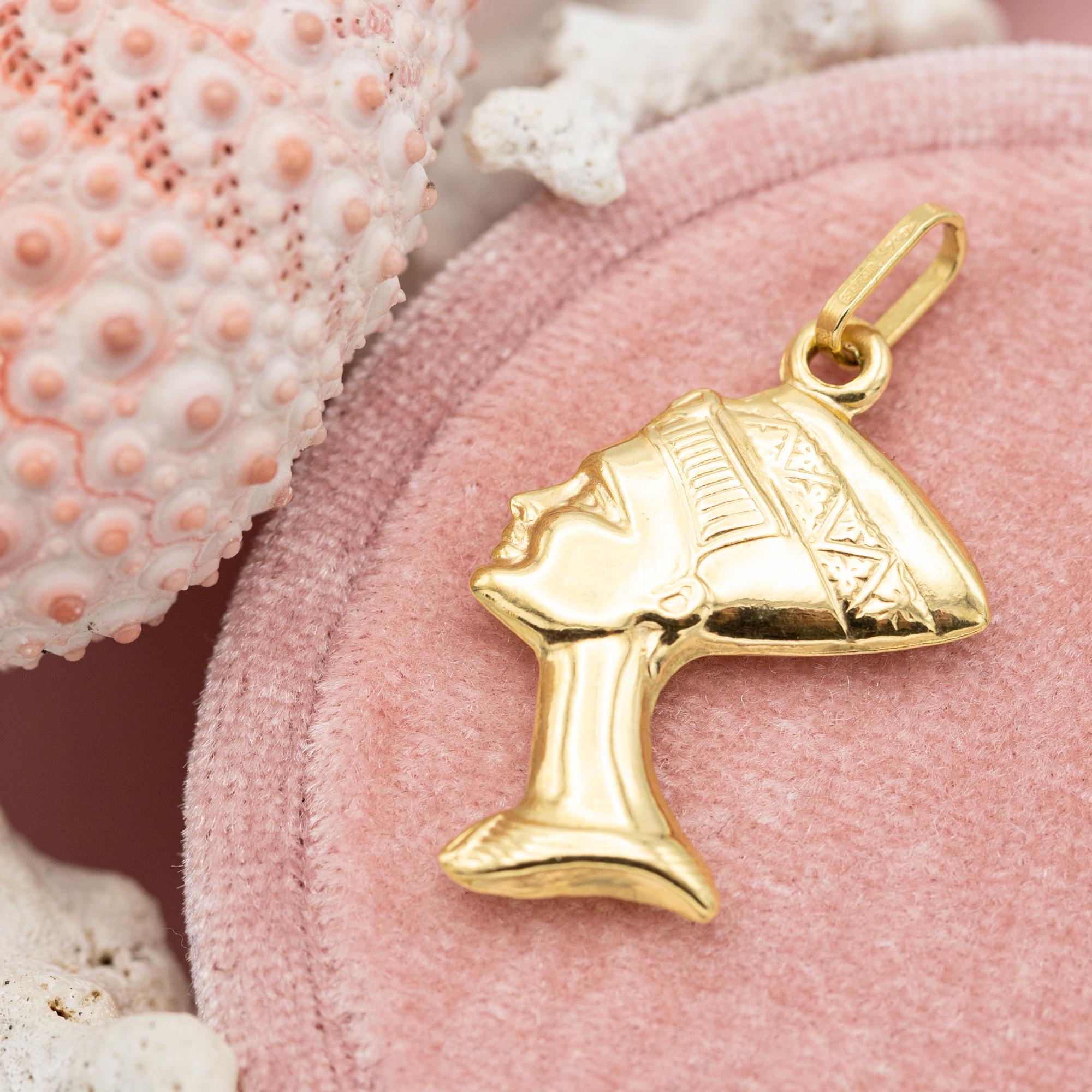 Nous vendons ce charme égyptien unique et puissant qui est l'un de nos nouveaux favoris ! Il est réalisé en or jaune 18 carats et représente la magnifique reine Néfertiti, une reine de l'Égypte ancienne. Il symbolise la beauté, le pouvoir et la