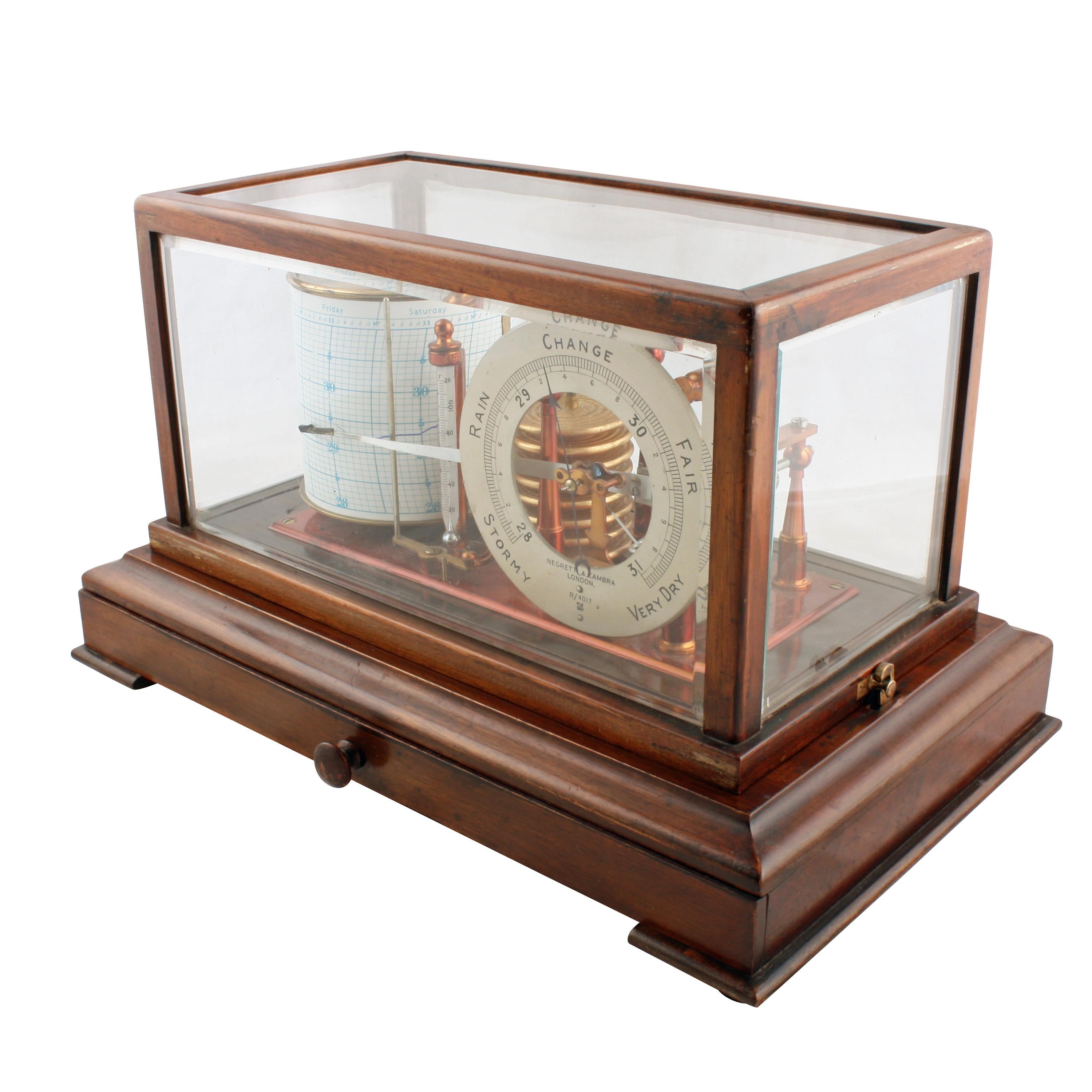An early 20th century glazed mahogany cased barograph by Negretti & Zambra.

The barograph has a clockwork revolving cylinder with recording paper and a barometric pressure viewing dial.

The interior also holds a brass and glass thermometer and
