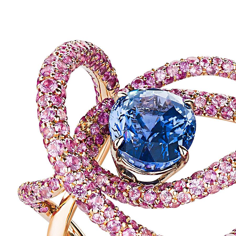 Kephi Ring by Neha Dani with a 3.93 Carat Blue Oval Natural Sapphire (no heat) is surrounded by 6.04 Carat Round Full Cut Pink Sapphires. The beautiful gems are set in 18K Rose Gold.