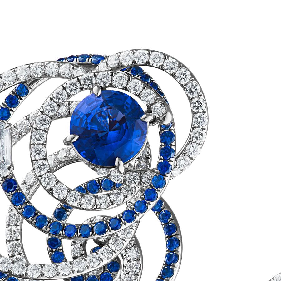 The Arshee Earrings by Neha Dani have a pair of 4.01 Carat Natural Blue sapphires, accented by 2 Shield cut Diamonds of 0.68 Carat. These are surrounded by circular spirals of 2.38 Carat Natural Blue Sapphires and 4.15 Carat of Full cut Diamonds.