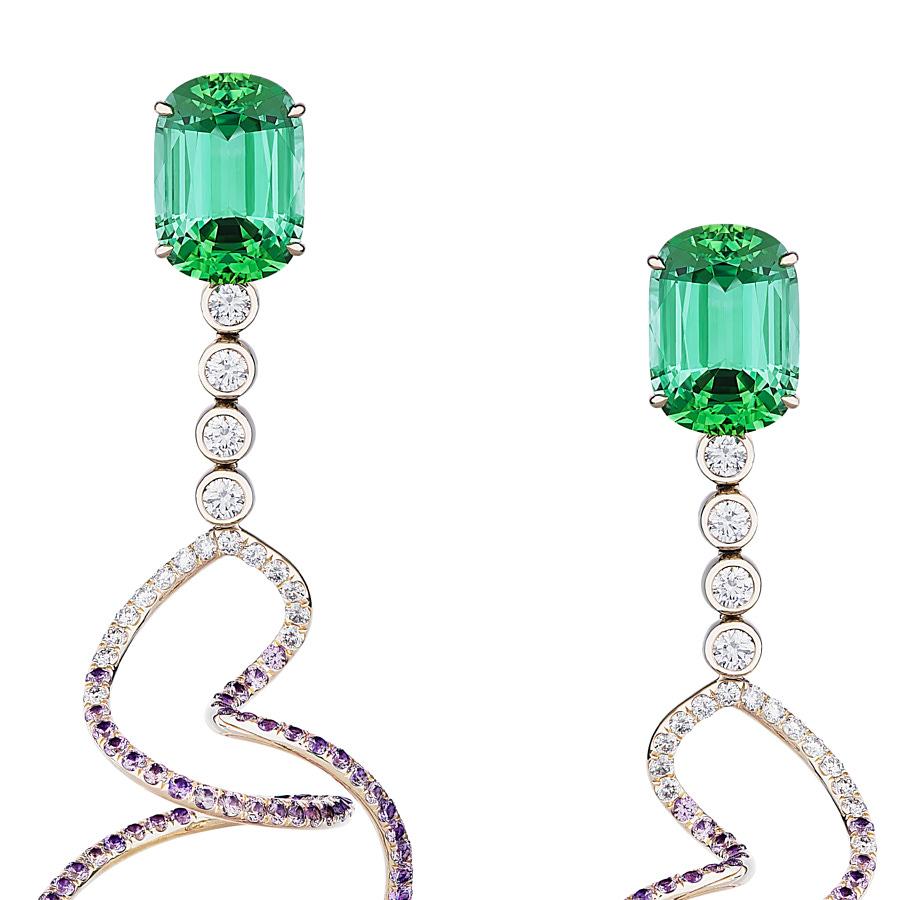 Eonia Earrings by Neha Dani has vivid elongated Cushion Cut Green Tourmalines of 11.44 Carats and 1.43 Carat Full Cut Diamonds that end in dangling spirals of 4.18 Carat Round Purple Sapphires. The swirling earrings are set in 18K White Gold.
