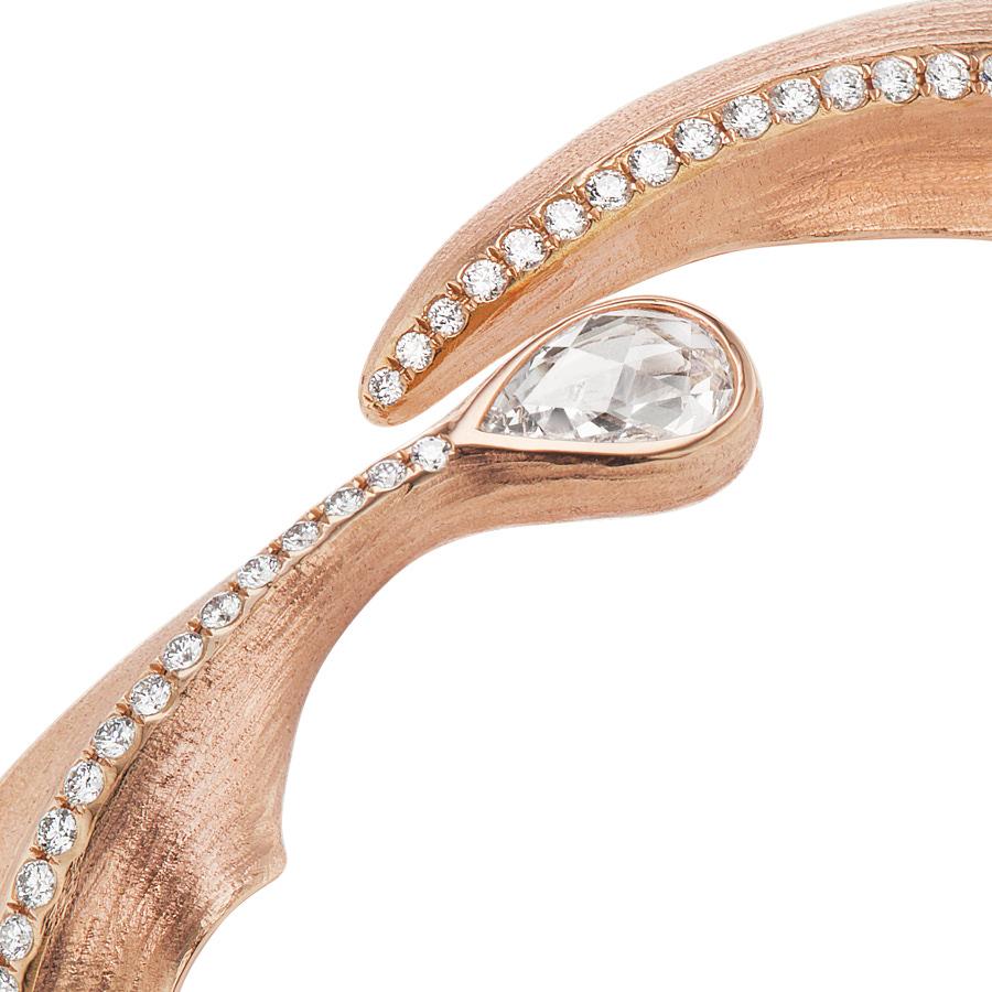The Alissa Leaf Bangle by Neha Dani is accented with a GIA Certified D-VVS2, 0.52 Carat Pear shape Rose Cut Diamond. Stunning to wear alone or layer, the bangle is made of 18K Rose Gold with a trail of 1.93 Carat Round Full Cut Diamonds.