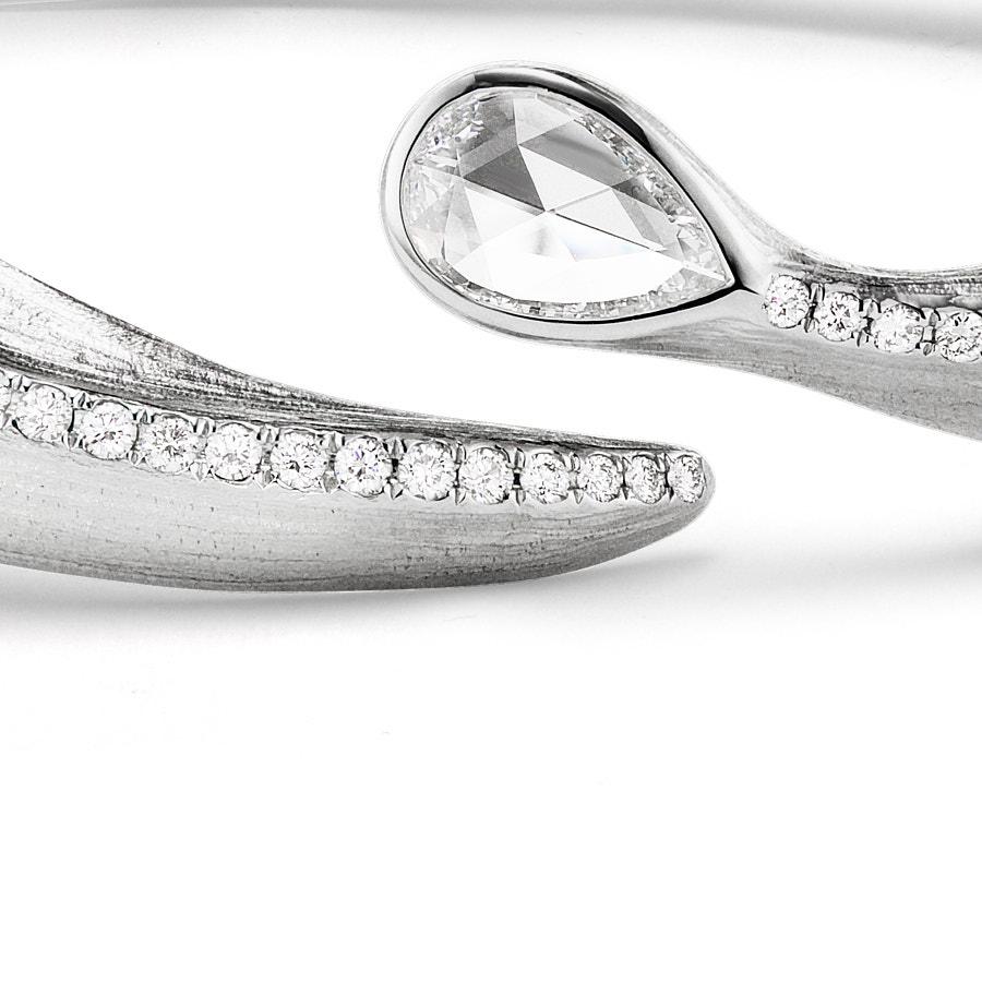 The Alissa Leaf Bangle by Neha Dani is accented with a GIA Certified DVVS 2, 0.54 Carat Pear shape Rose Cut Diamond. Stunning to wear alone or layer, the bangle is made of 18K White Gold with a trail of 2.13 Carat Round Full Cut Diamonds.