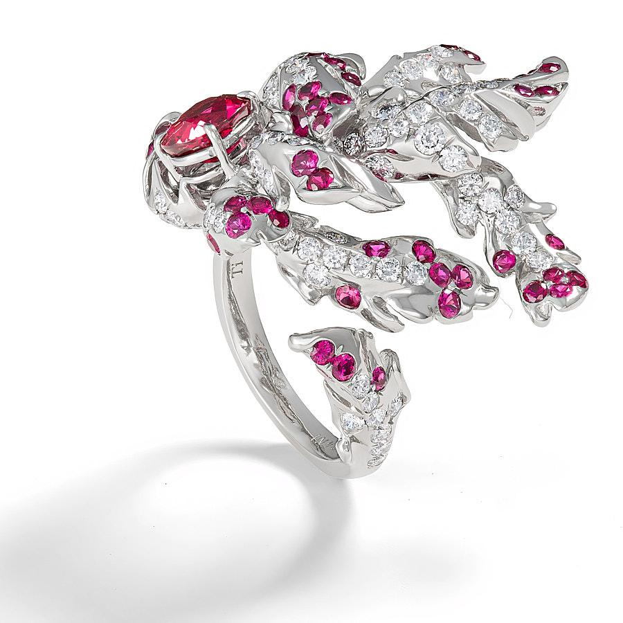 The Scarlet Ring by Neha Dani is sculpted with a wreath of grey Titanium feathers set with 1.31 Carat Round Brilliant Cut Diamonds and 1.22 Carat Rubies. The deep red of a certified Oval Mozambique Ruby of 1.41 Carat is a wellspring for the fluid