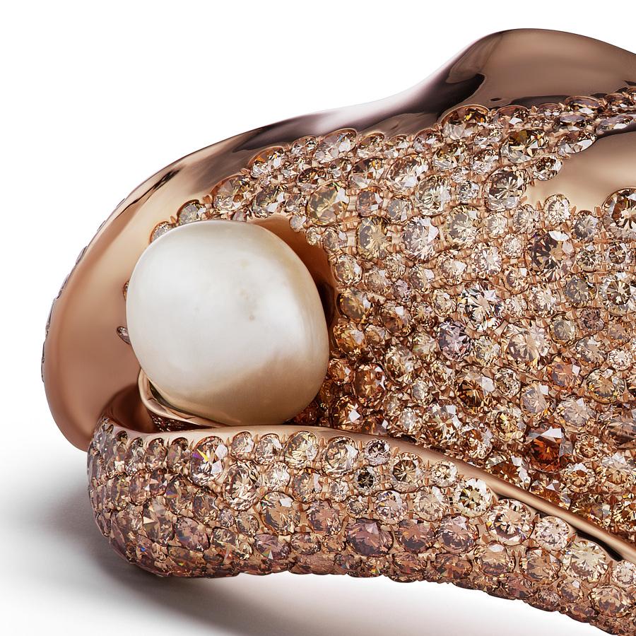 The Karesa Cuff Bracelet unfurls like a leaf to showcase an 8.98 Carat Natural Baroque Pearl, nestled in the core. 18.2 Carat Brown Diamonds accent the bracelet made of 18 K Rose Gold.
