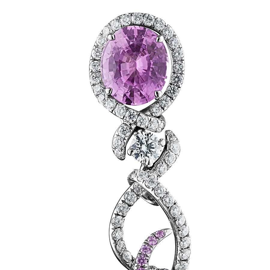 Advay Earrings by Neha Dani feature a pair of Natural Purple Oval Sapphires of 3.97 Carat surrounded by fluid swirls of Round Diamonds (2.48 Carat) and Sapphires (0.96 Carat). These flow down to 2 Shield-Cut White Diamonds of 1.08 Carat. The
