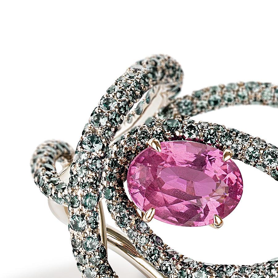 The Kephi Ring by Neha Dani resonates joy in a 3.06 Carat Natural Oval Pink Sapphire, which is surrounded by 6.30 Carat Round Full Cut Green Garnets. Set in 18K White Gold, the ring is a symbol of exuberance.