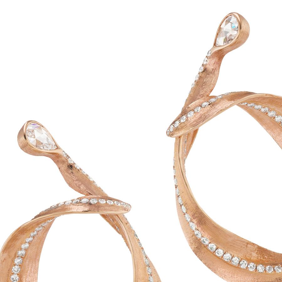 Callista Hoop Earrings are designed as a pair of leaf shaped hoops by Neha Dani, lined with 2.90 Carat Full Cut Diamonds. The hoops are in 18K Rose Gold and are anchored at the earlobes by a pair of Pear Shape Rose Cut White Diamonds of 1 Carat.