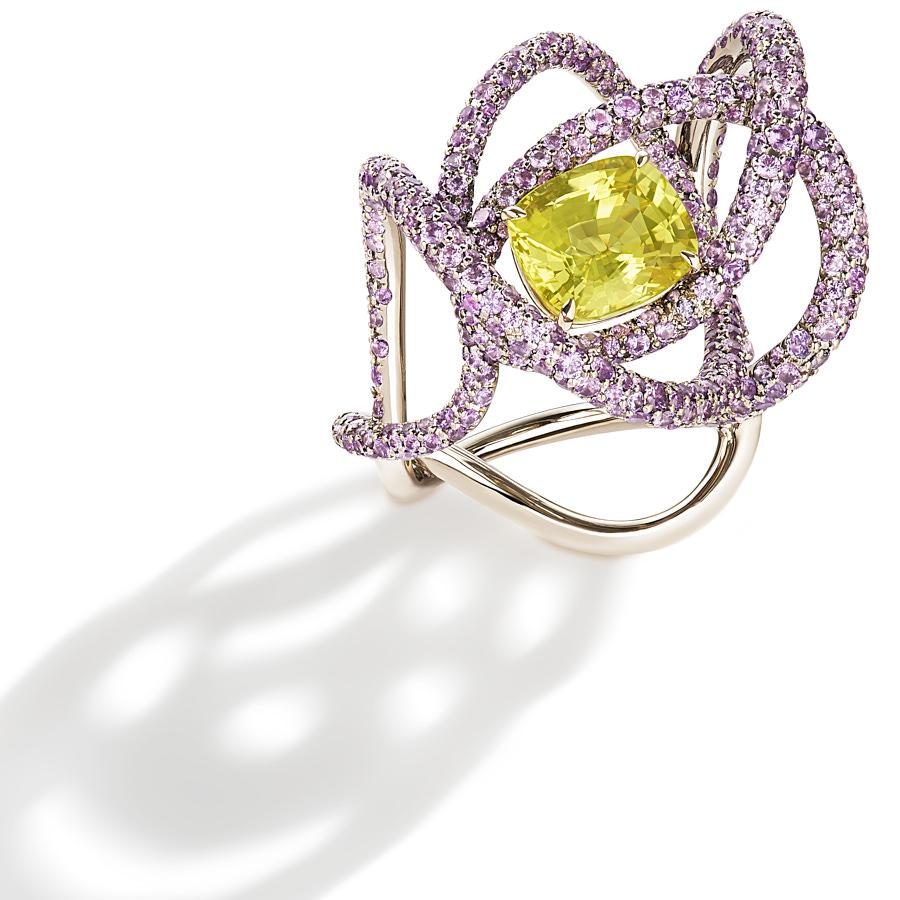 The Kephi Ring by Neha Dani resonates joy in a 4.46 Carat Natural Cushion (no heat) Yellow Sapphire, which is surrounded by 6.08 Carat Round Full Cut Purple Sapphires. Set in 18K White Gold, the ring is a symbol of exuberance.