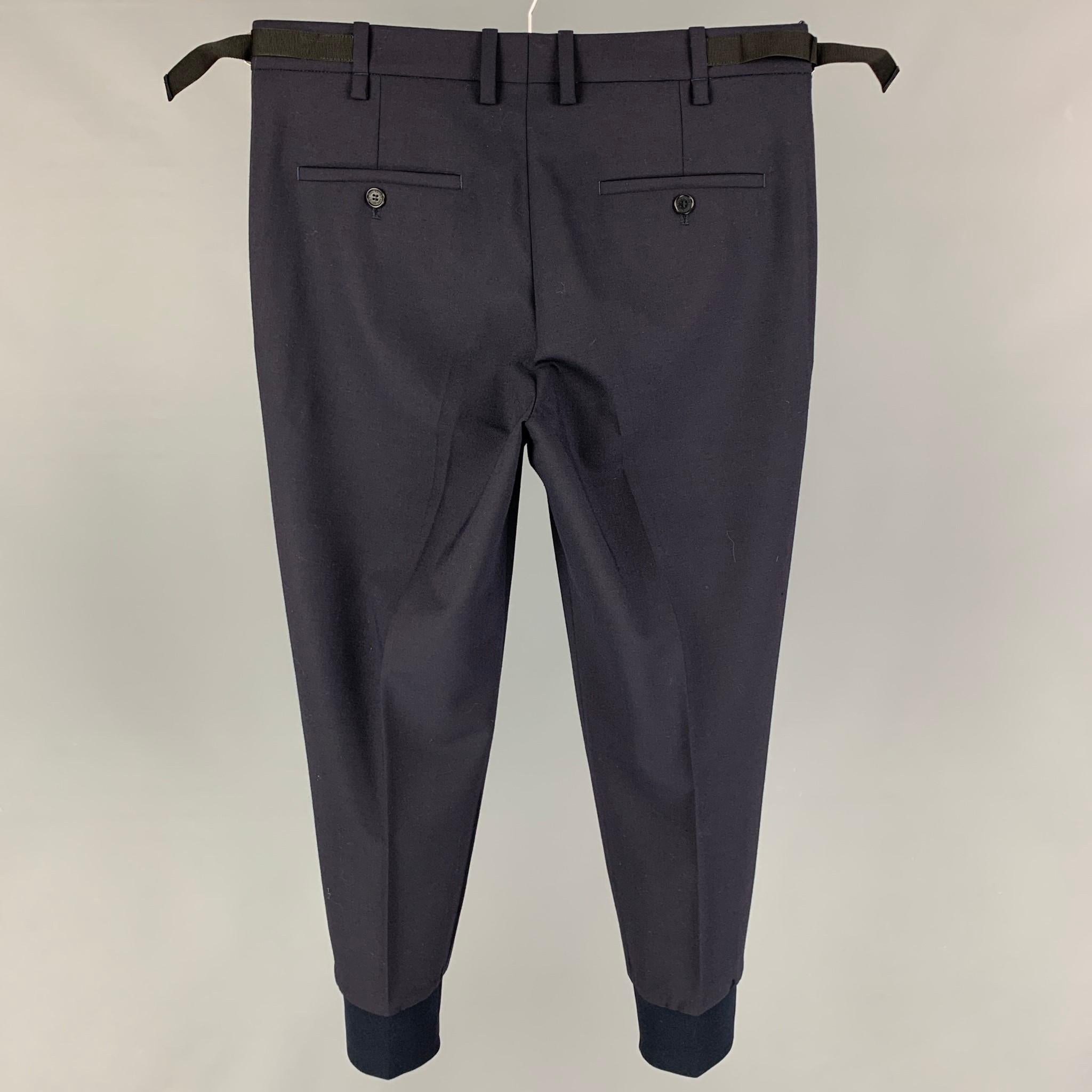 NEIL BARRETT dress pants comes in a navy wool blend featuring a skinny fit, flat front, elastic cuffs, side tabs, and a zip fly closure. 

Very Good Pre-Owned Condition.
Marked: 46
Original Retail Price: $590.00

Measurements:

Waist: 32 in.
Rise:
