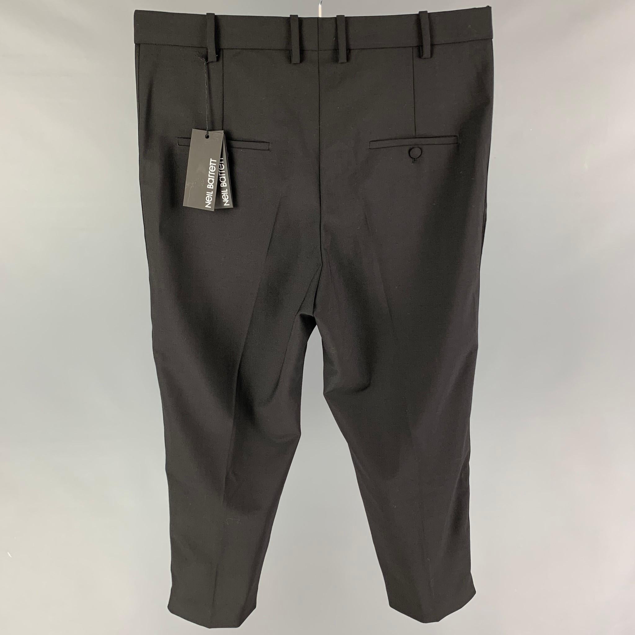 NEIL BARRETT dress pants comes in a black polyester blend featuring a flat front, cropped leg, tuxedo stripe, front tab, and a zip fly closure. Made in Italy. 

New With Tags.
Marked: 52

Measurements:

Waist: 37 in.
Rise: 15 in.
Inseam: 24 in. 