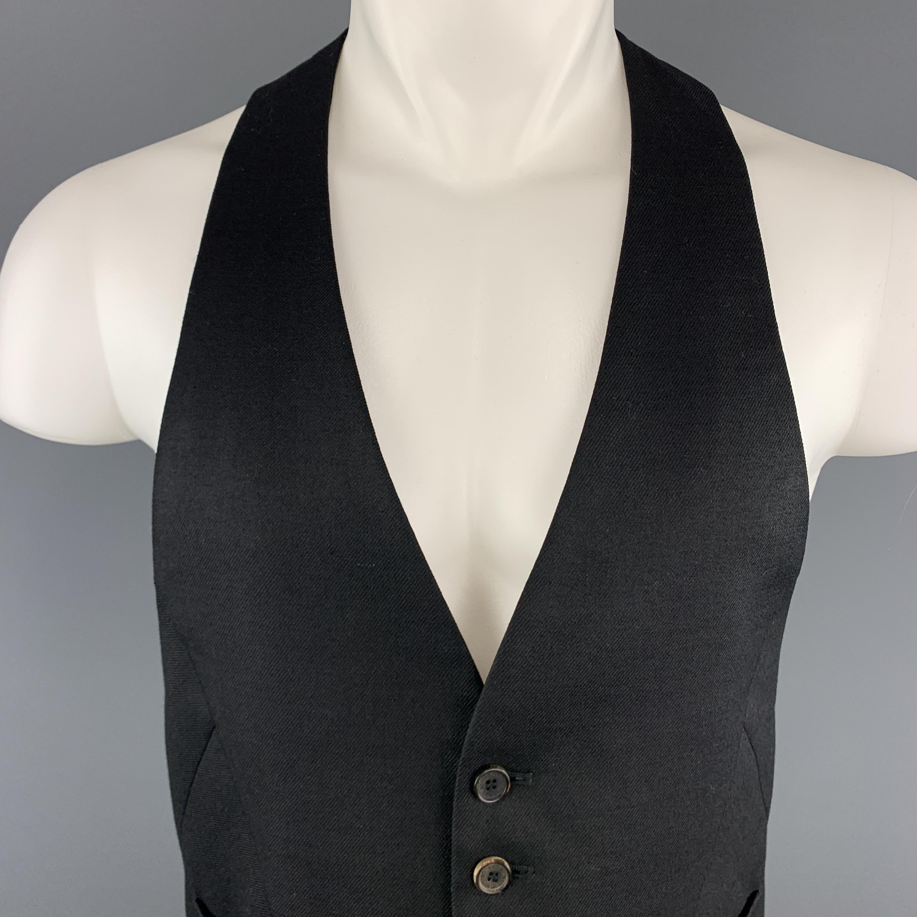 NEIL BARRETT vest comes in black wool twill with a deep V neck front, slanted cut front, and racer cut harness belt buckle back. Made in Italy.

Excellent Pre-Owned Condition.
Marked: IT 48

Measurements:

Shoulder: 9.25 in.
Chest: 38 in.
Length: 25