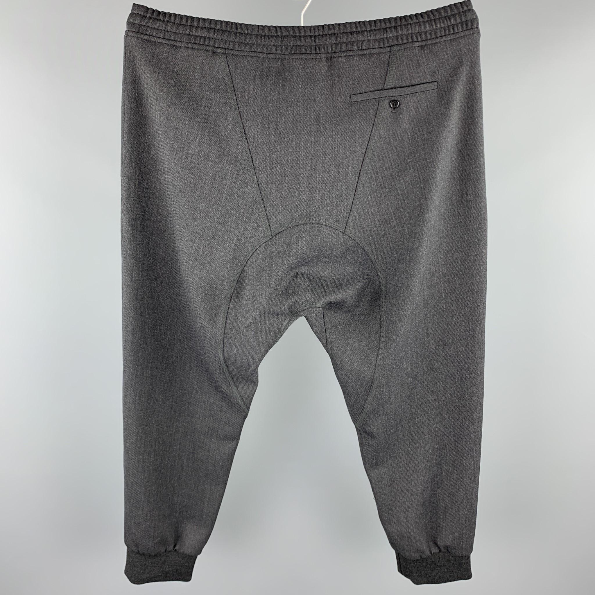 NEIL BARRETT casual pants comes in a charcoal wool blend featuring a slouch fit, low rise, elastic waistband, and a drawstring closure.

New With Tags. 
Marked: IT 54
Original Retail Price: $520.00

Measurements:

Waist: 38 in. 
Rise: 8 in. 
Inseam: