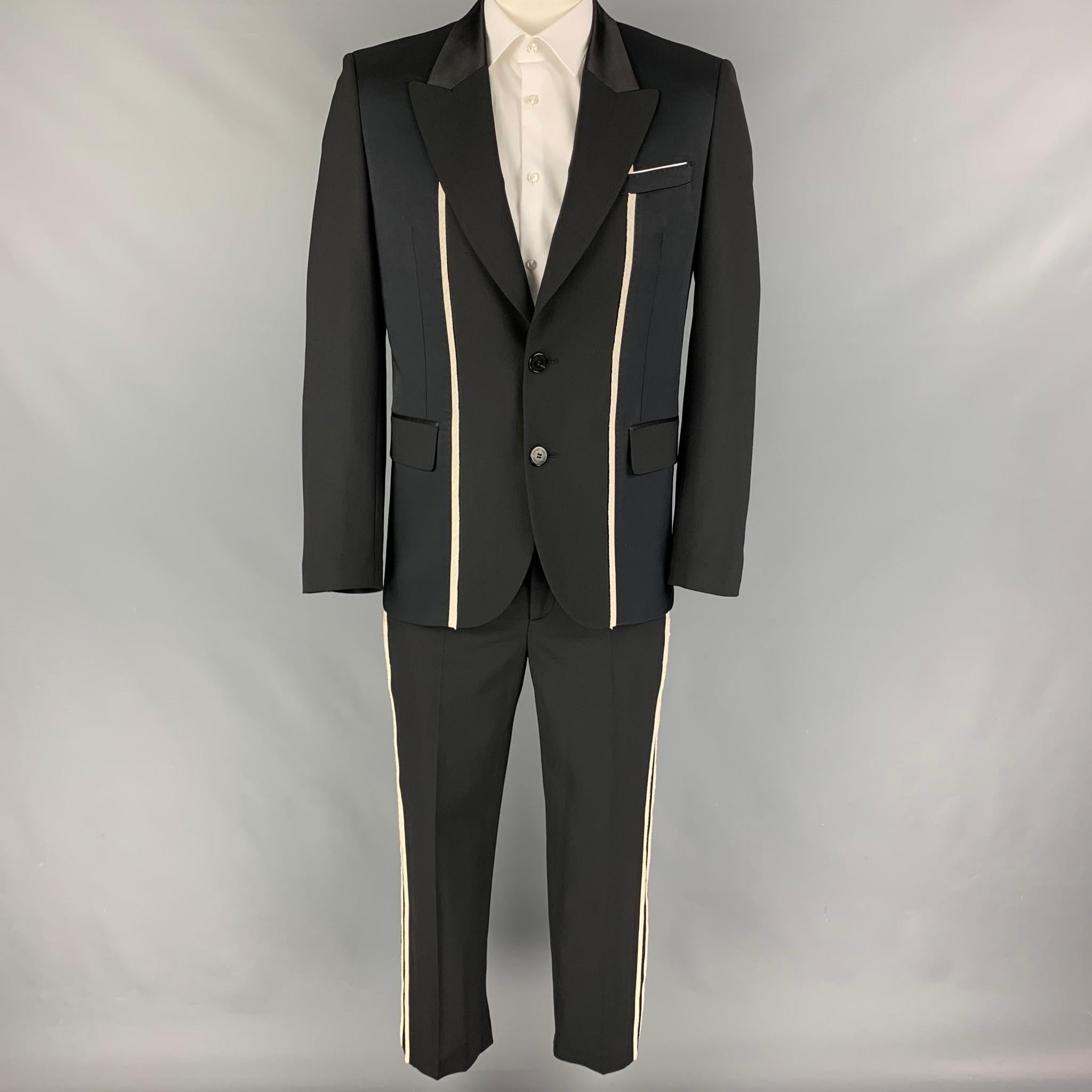 NEIL BARRETT 'Slim Fit' suit comes in a black & white polyester blend with a full liner and includes a single breasted, double button sport coat with a peak lapel and matching flat front trousers. Made in Italy.

Very Good Pre-Owned