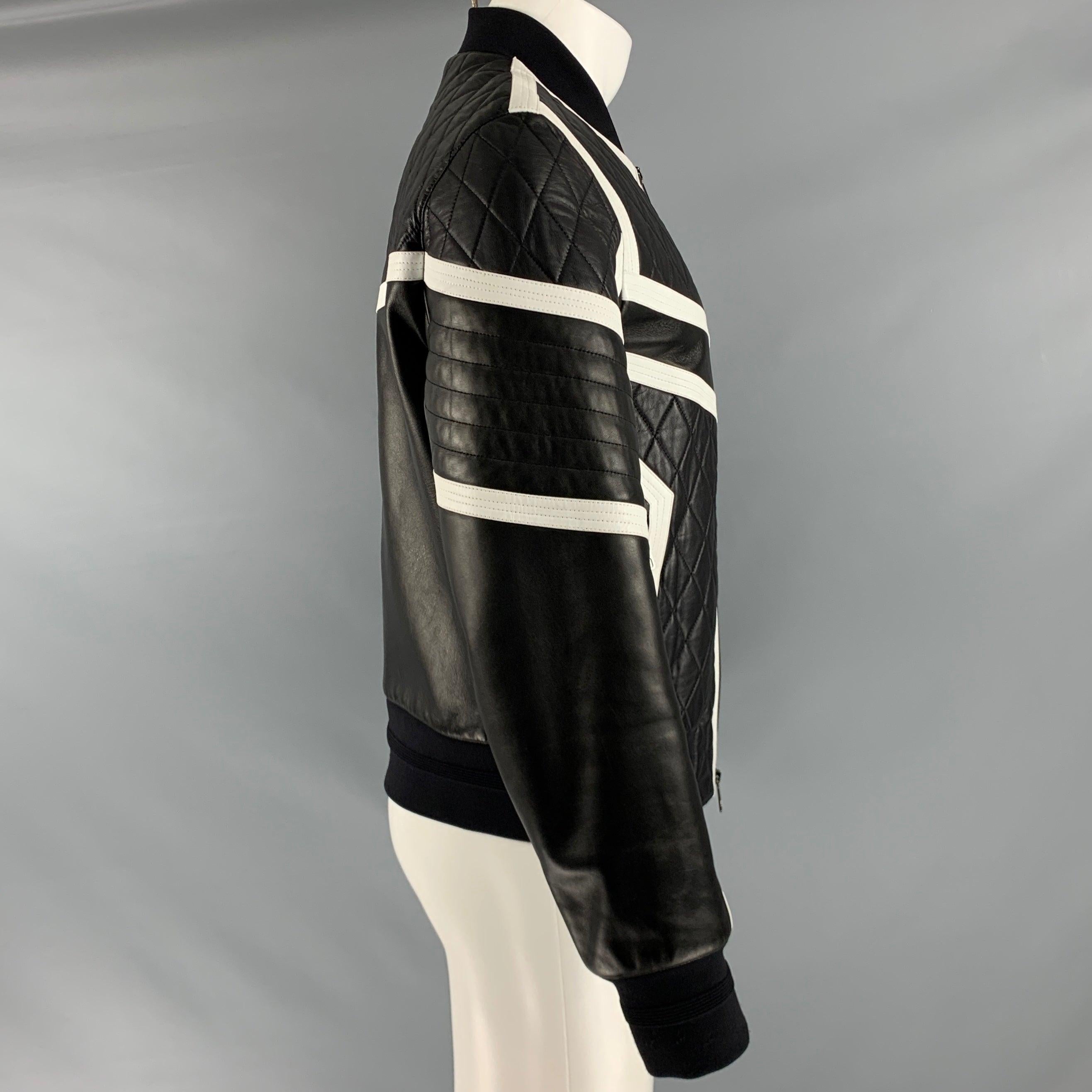 chaqueta NEIL BARRETT
en un tejido de piel negra con un estilo acolchado, rayas de piel blanca en contraste y cierre de cremallera. Made in Italy. Muy buen estado de conservación. Marcas en la manga izquierda. 

Marcado:   M 

Medidas: 
 
Hombro