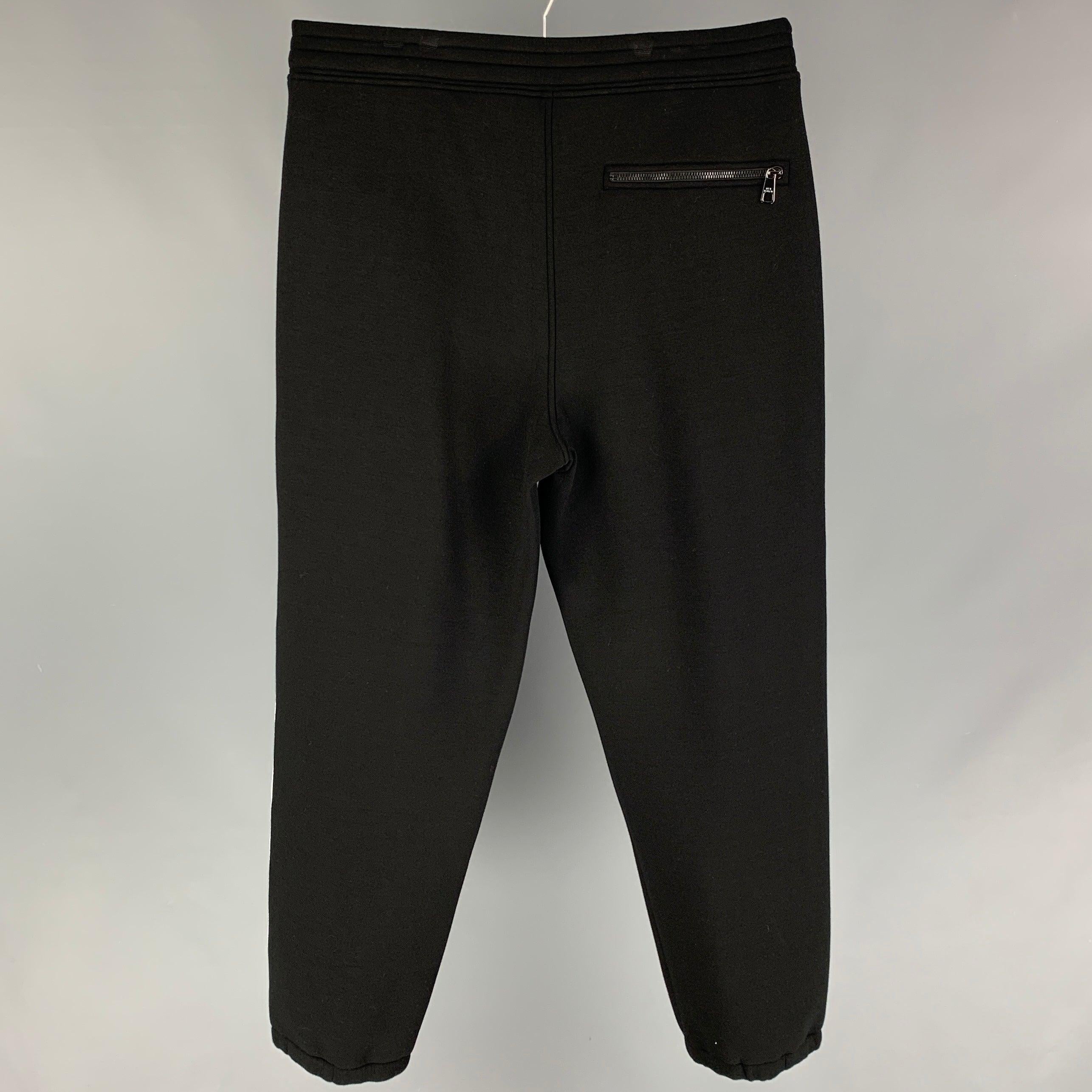 NEIL BARRETT sweat pants comes in a black & white viscose with a side stipe featuring a easy fit, leather patch detail, and a elastic waistband.
New With Tags. 

Marked:   XL  

Measurements: 
  Waist: 36 inches  Rise: 14.5 inches  Inseam: 30 inches